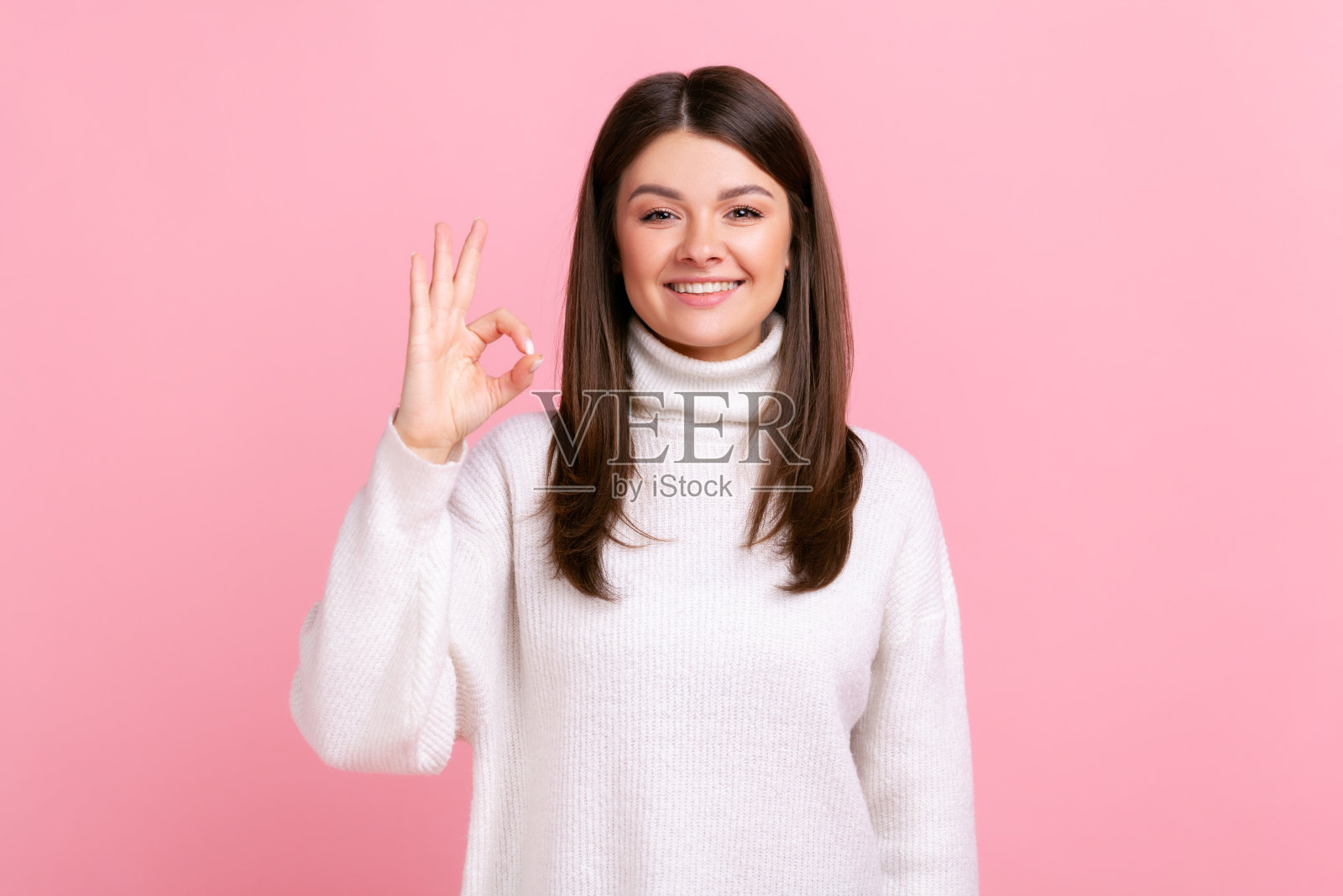 积极的有吸引力的女人对着镜头做出ok的手势，用积极的表情表示赞许。照片摄影图片