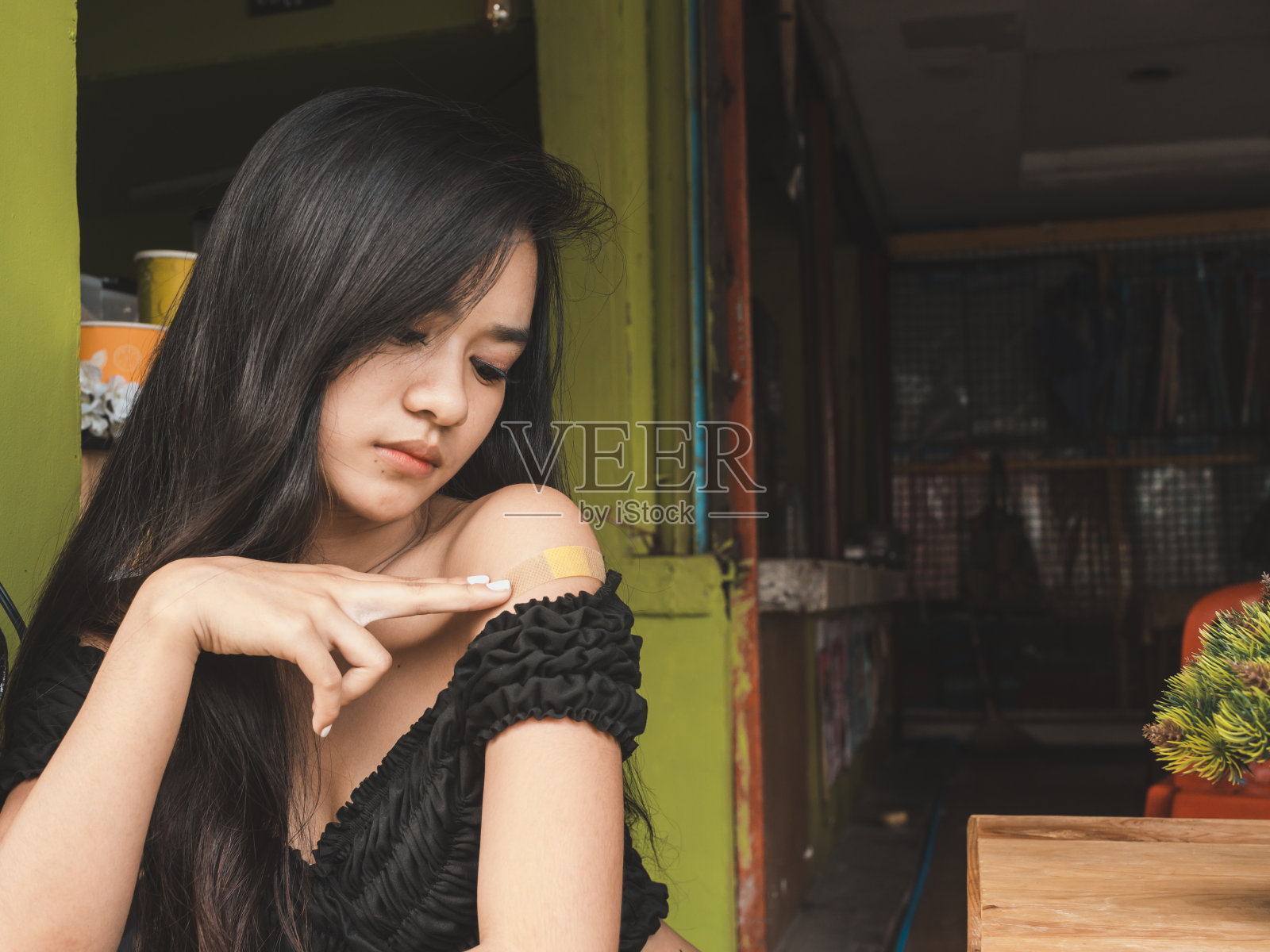 一个可爱的亚洲女孩检查和担心盖疮是搏动着一些疼痛。可能的疤痕。照片摄影图片