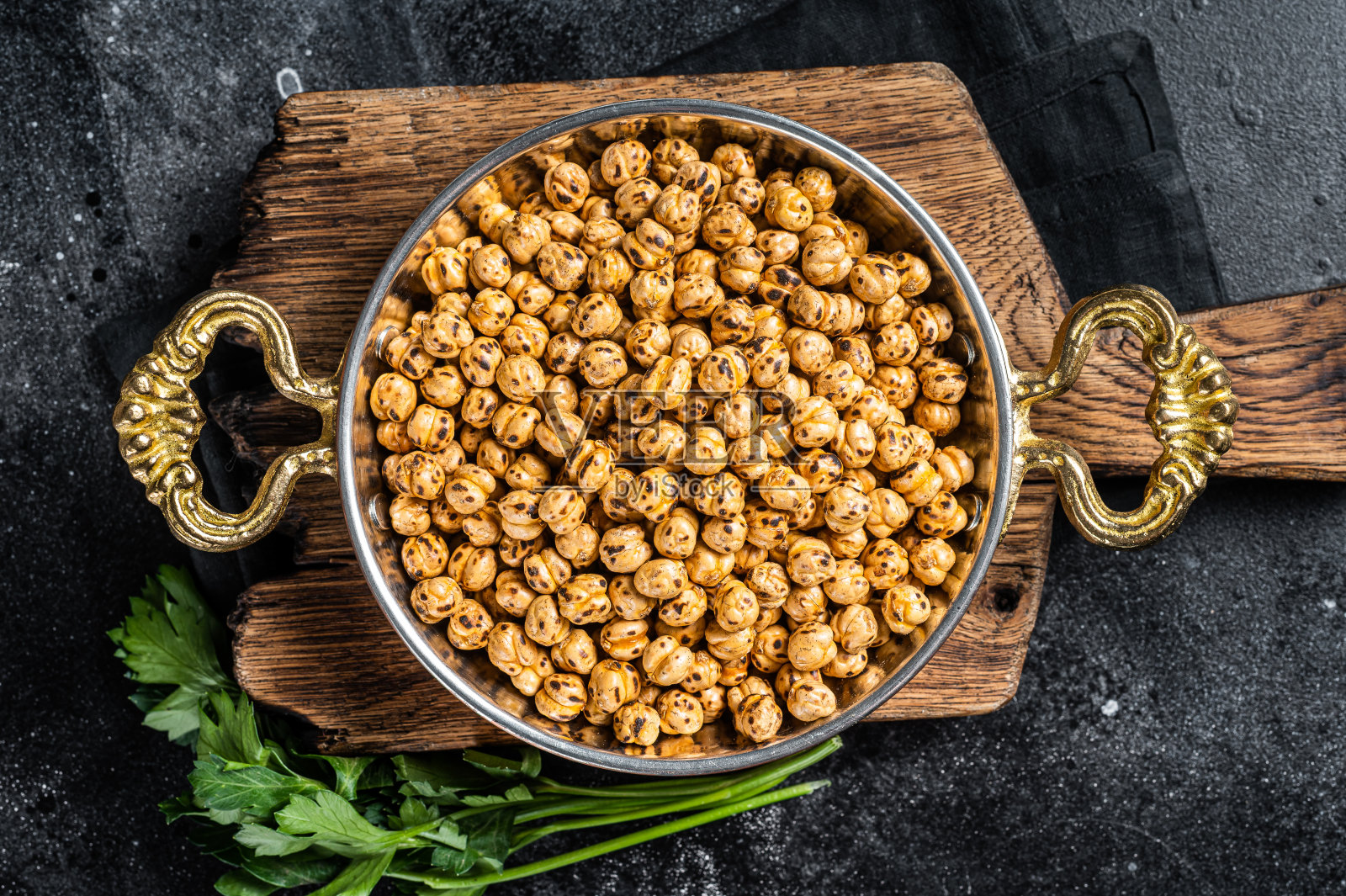 姜黄炒鹰嘴豆，辣鹰嘴豆或印度chana或cholole在煎锅里。黑色背景。俯视图照片摄影图片