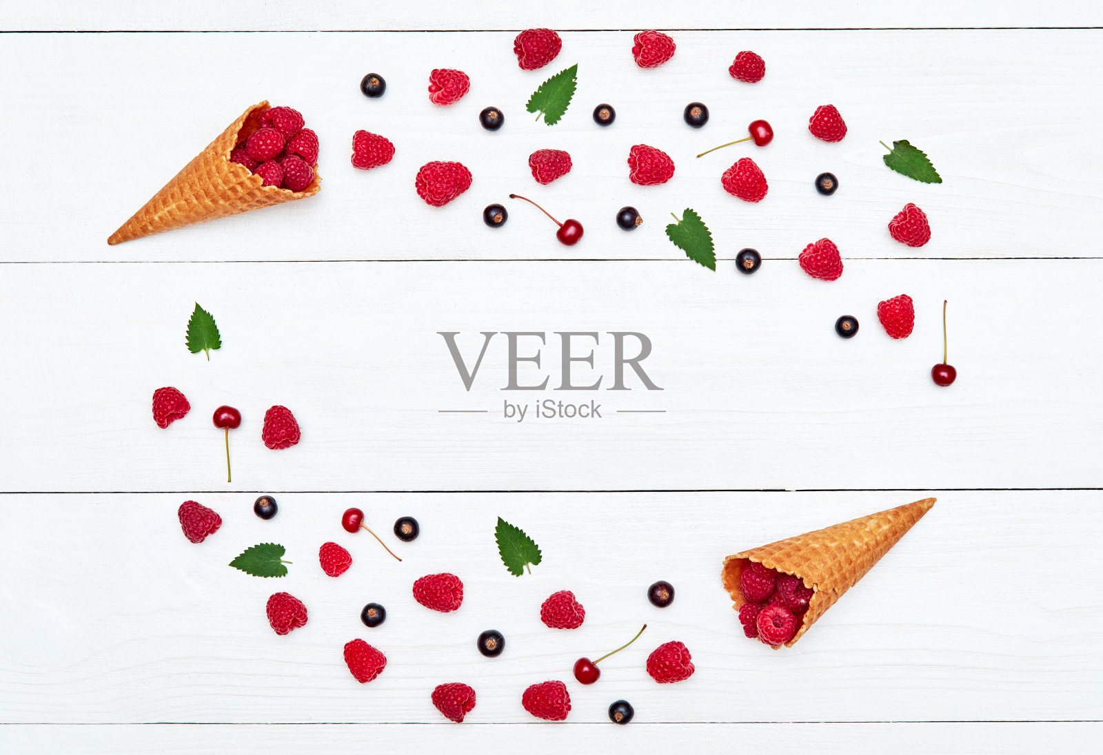 圈框从成熟的甜覆盆子，樱桃和黑醋栗，复制空间。新鲜浆果在白色木制背景。夏日，健康饮食理念。浆果背景照片摄影图片