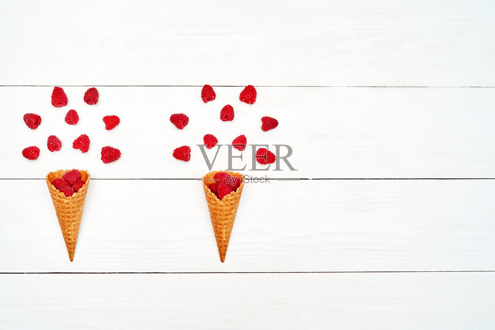 熟透的甜树莓冰淇淋华夫蛋筒，复印空间。新鲜浆果白色木制背景，自由空间。夏日与健康饮食理念。俯视图，平躺。浆果背景照片摄影图片