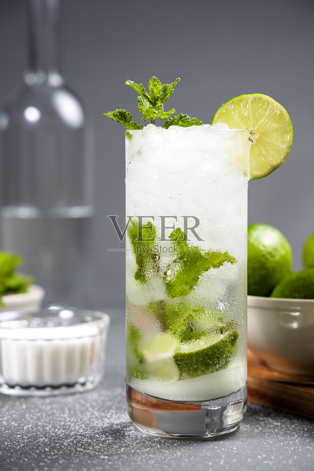 灰色桌子上放着莫吉托鸡尾酒。一些配料作为背景照片摄影图片