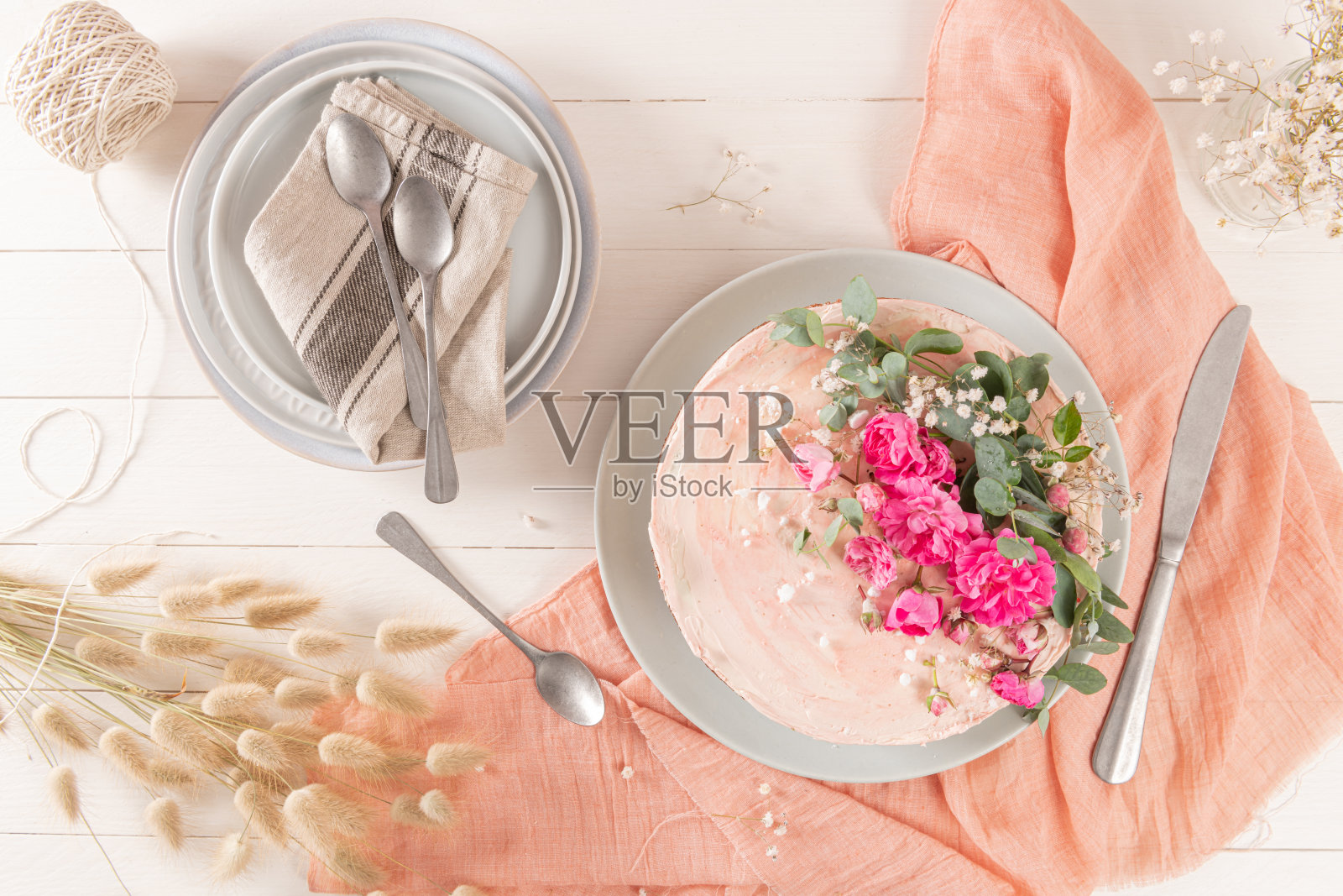 巧克力裸蛋糕，白色背景上有新鲜的玫瑰和瑞士奶油照片摄影图片