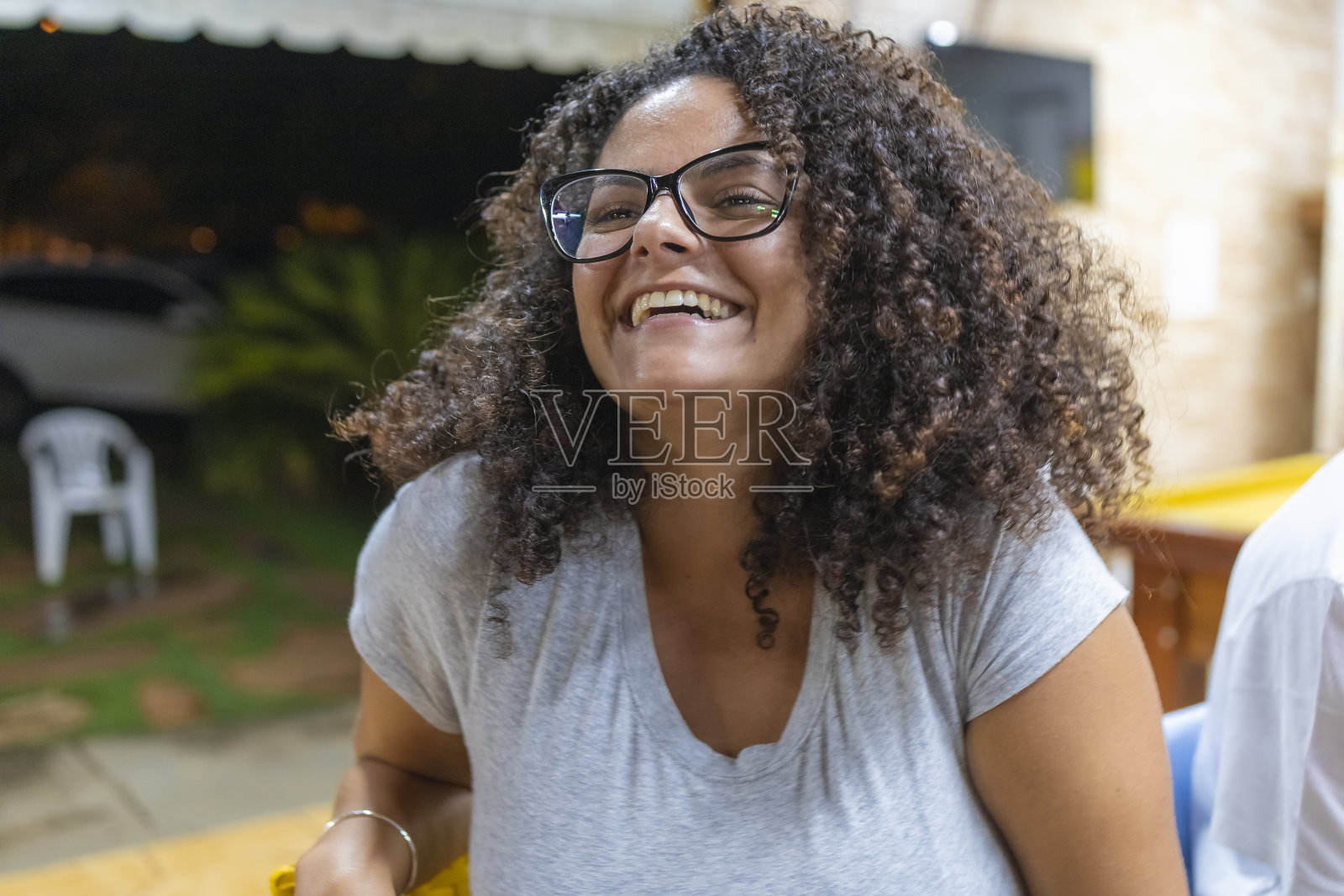 戴眼镜的非洲裔女孩对着镜头微笑，背景模糊照片摄影图片