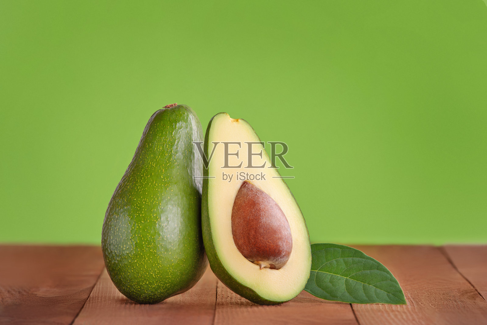 鳄梨在木制和绿色的背景照片摄影图片