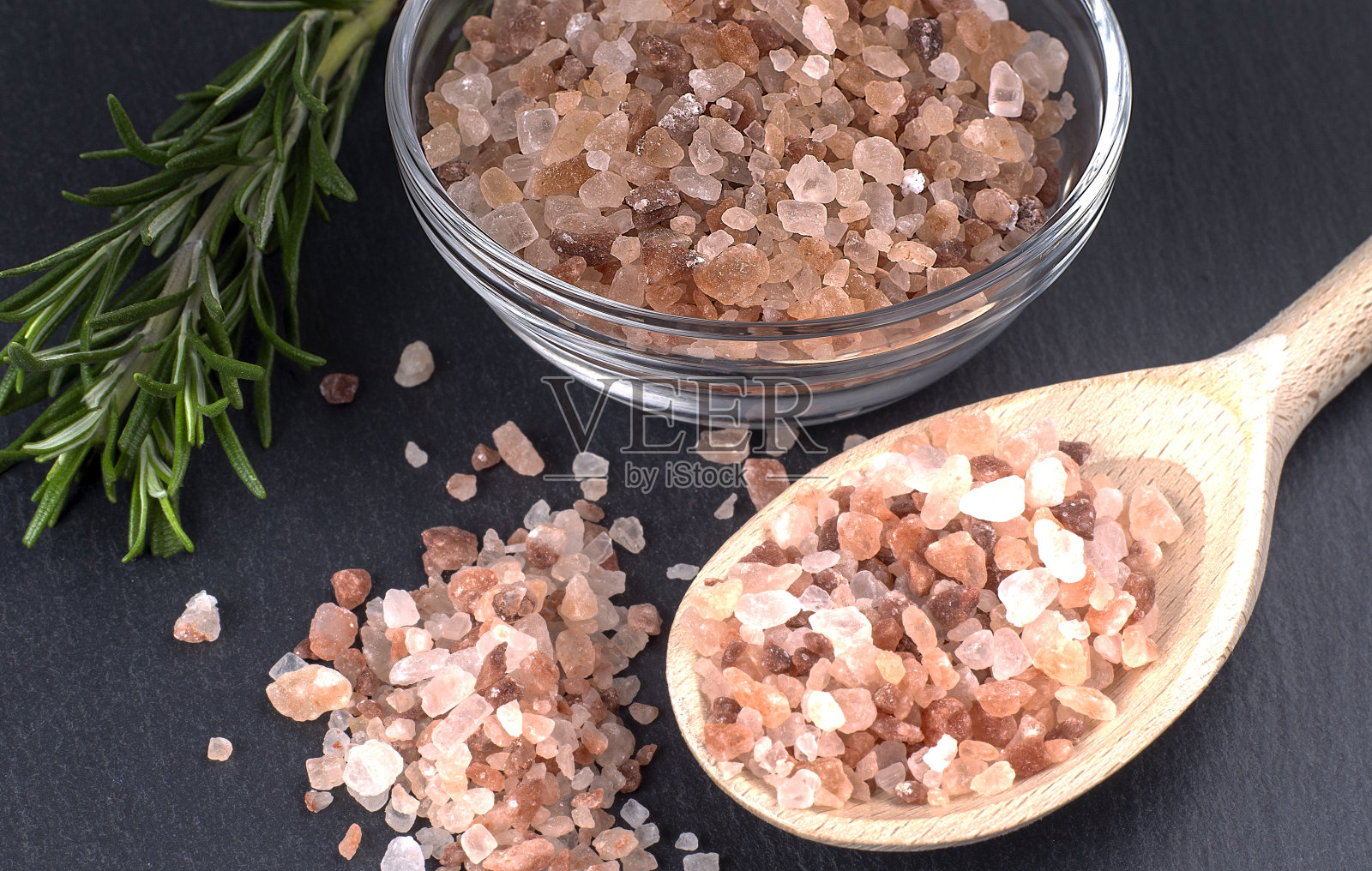 木勺，粉红色喜马拉雅盐，深色背景，迷迭香照片摄影图片