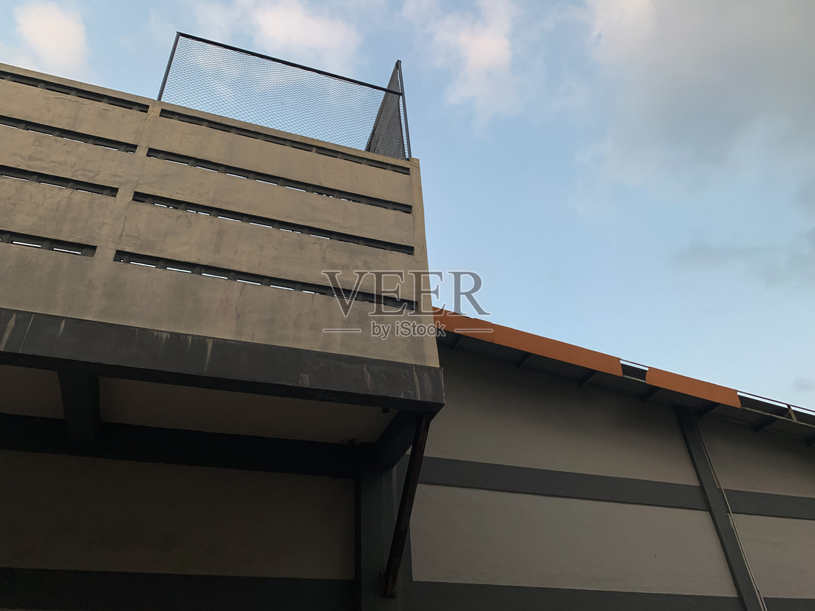 带楼梯的网球场旁边的仓库屋顶照片摄影图片