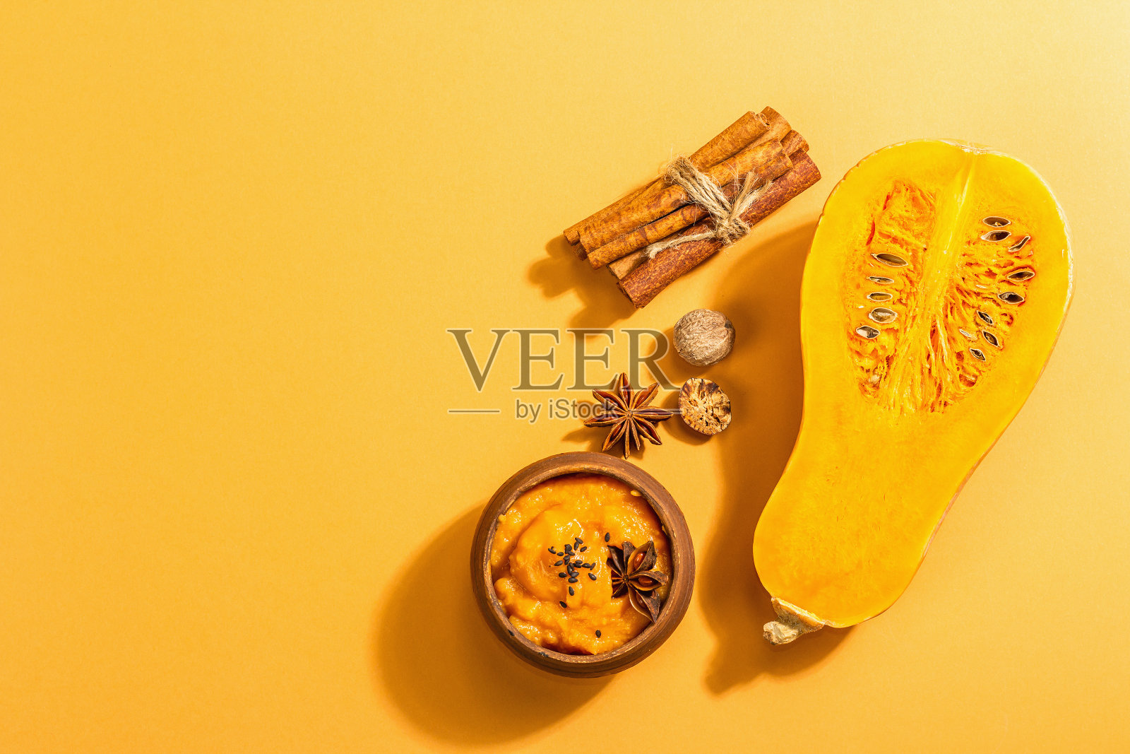 一半的生南瓜加冬南瓜泥和香料。烹饪用的各种配料照片摄影图片