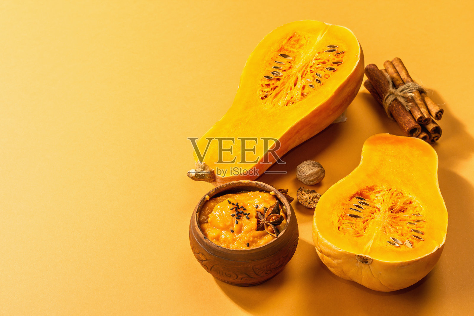 一半的生南瓜加冬南瓜泥和香料。烹饪用的各种配料照片摄影图片
