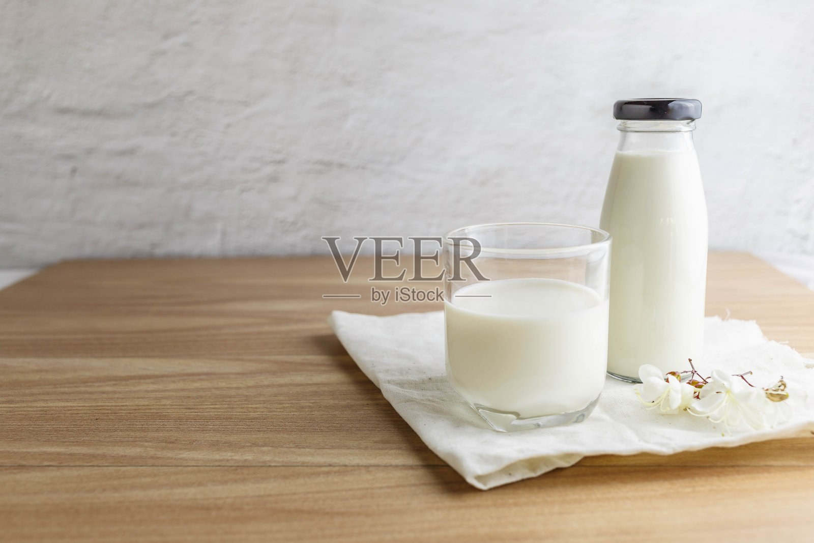 木桌上放着一瓶牛奶和一杯牛奶照片摄影图片