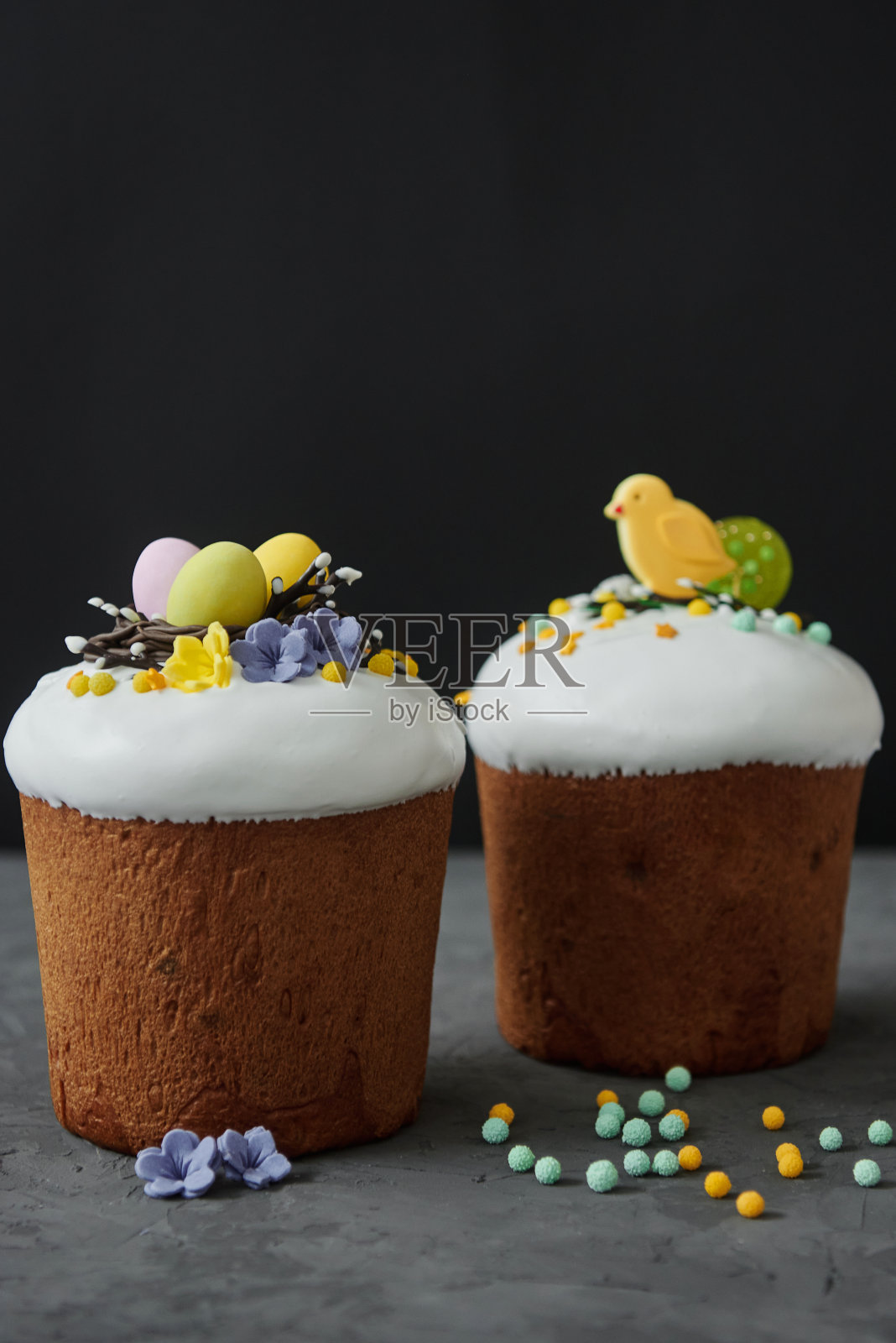 上釉的复活节蛋糕装饰鸟巢蛋，花和糖果在黑暗的背景，复制空间。快乐的复活节假期。Kulich照片摄影图片