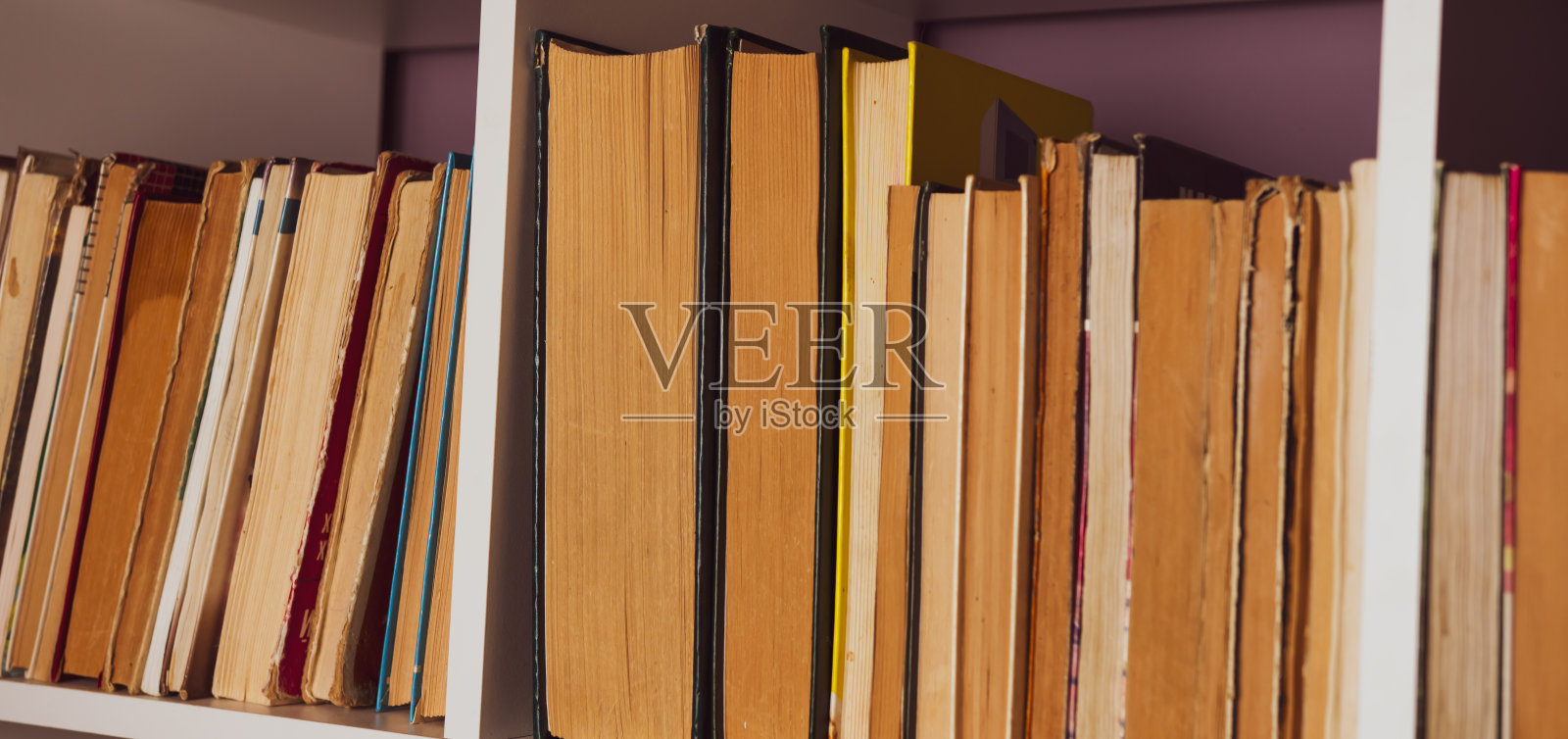 书架上有旧书。图书馆书架上的书照片摄影图片