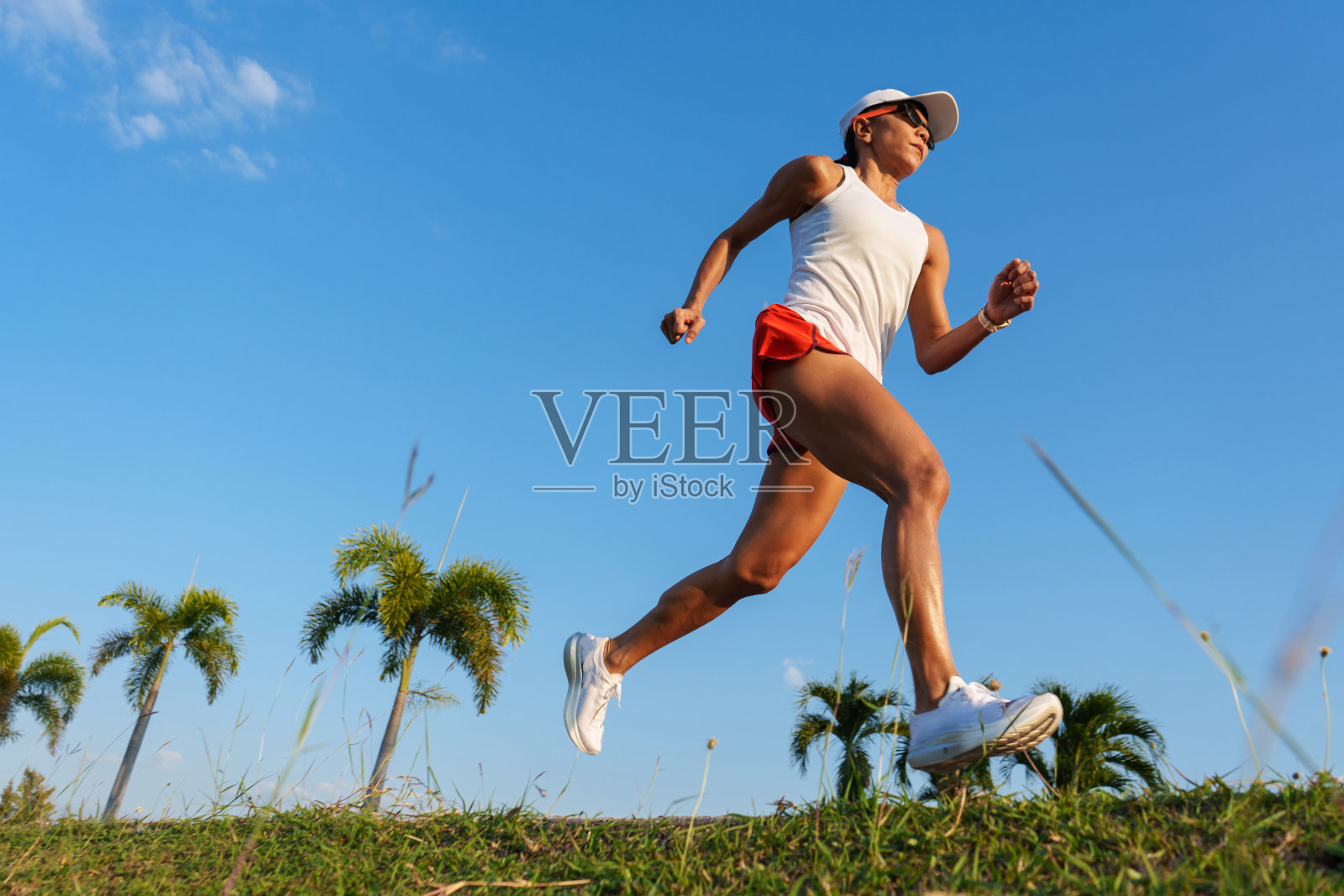 成熟的女人在蓝天上跑步，健康训练的生活方式照片摄影图片