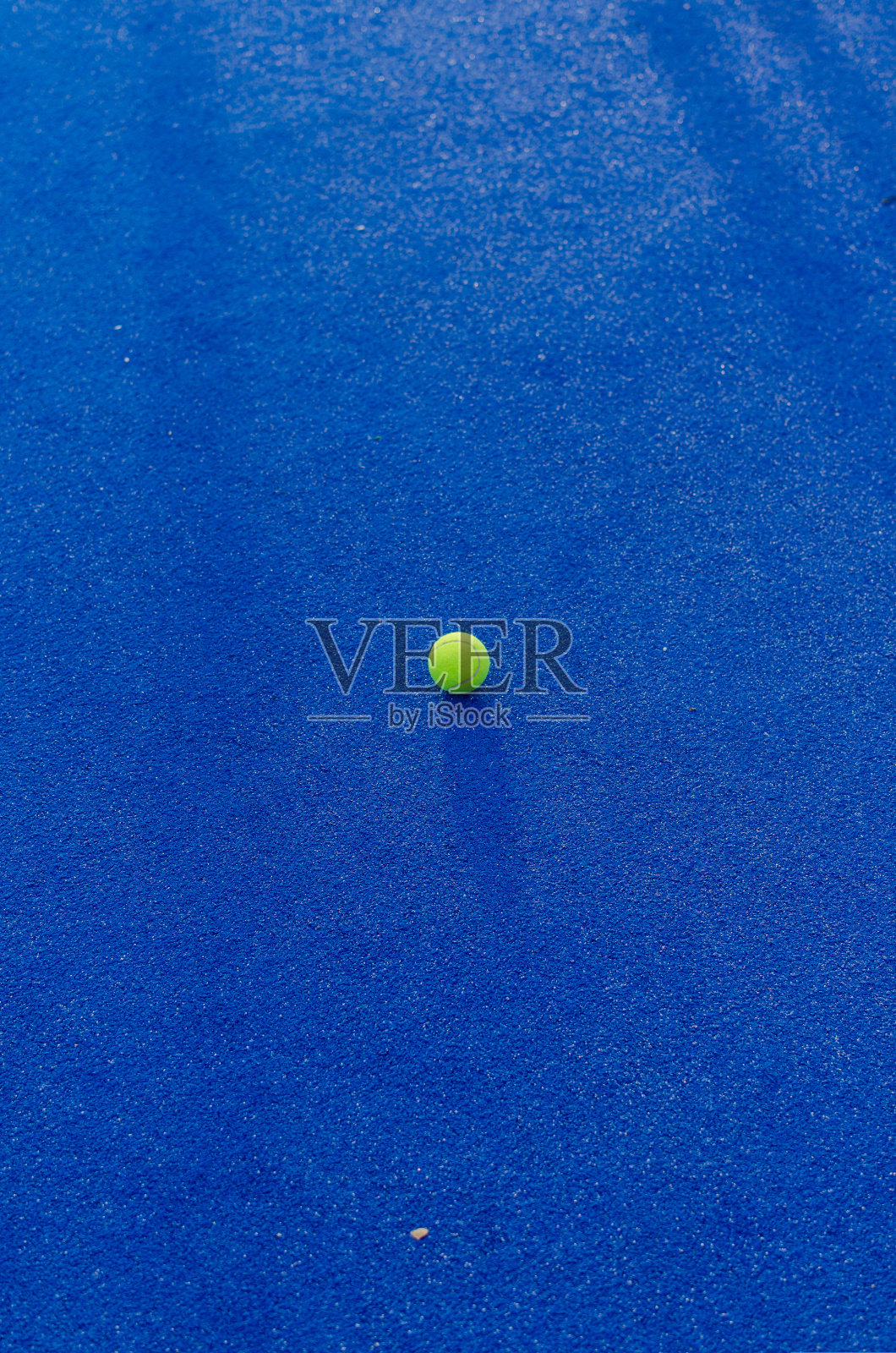 蓝网球场上的孤立球照片摄影图片