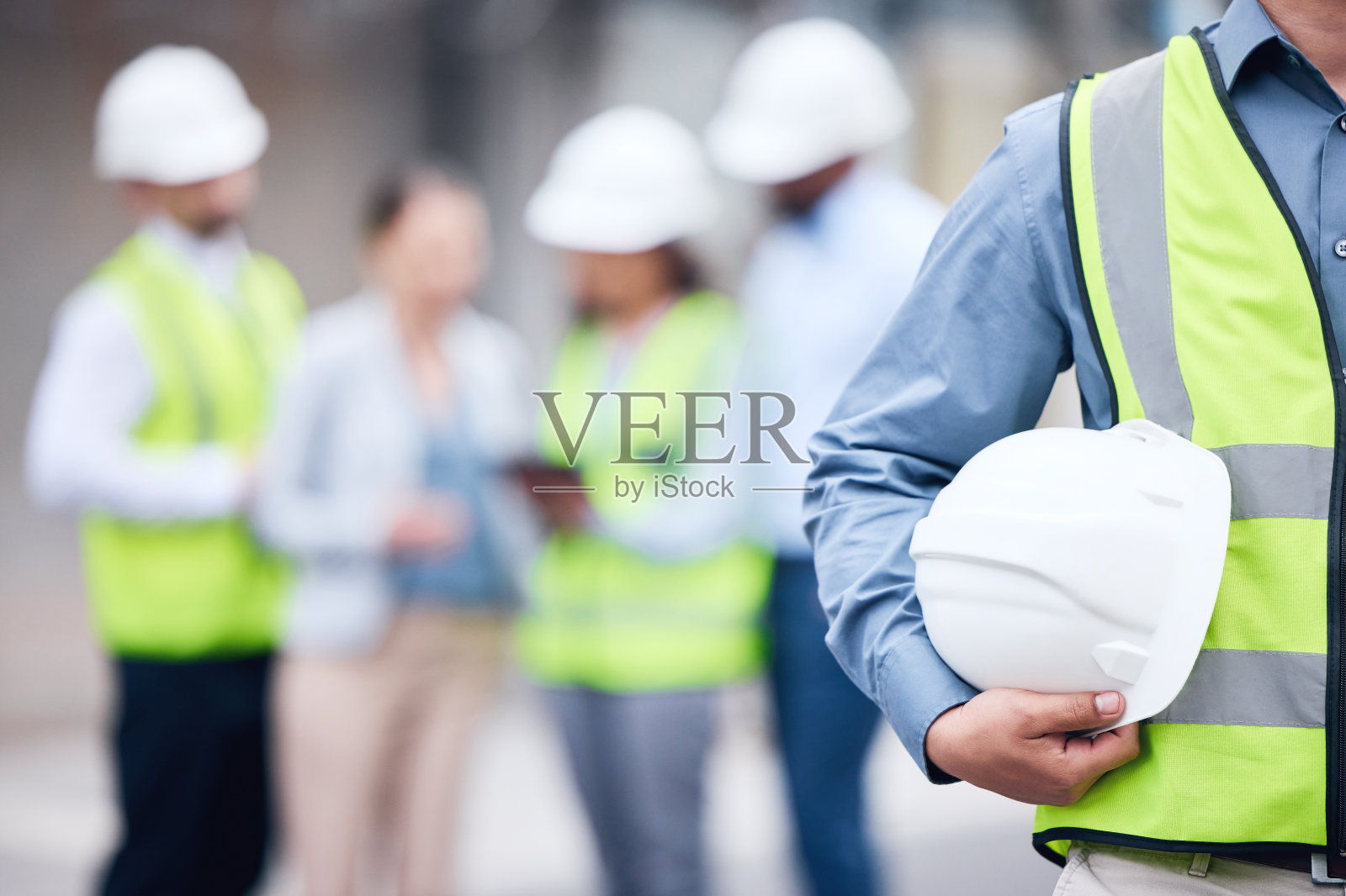 一个不知名的建筑师在一个建筑工地拿着头盔的照片照片摄影图片