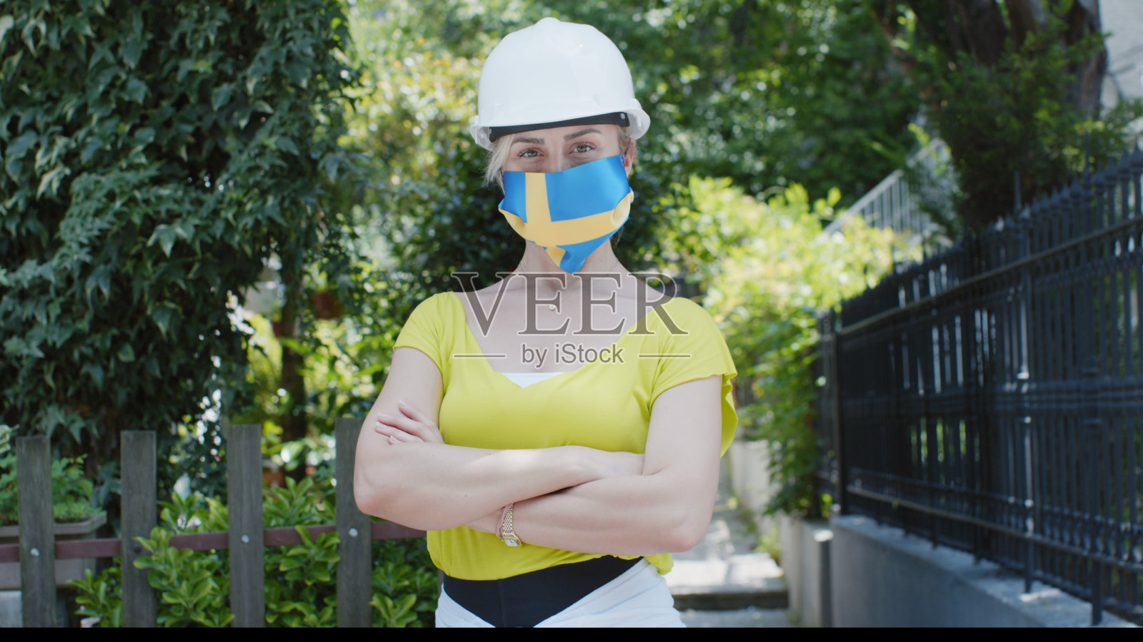 戴瑞典国旗口罩和头盔的女工程师肖像照片摄影图片