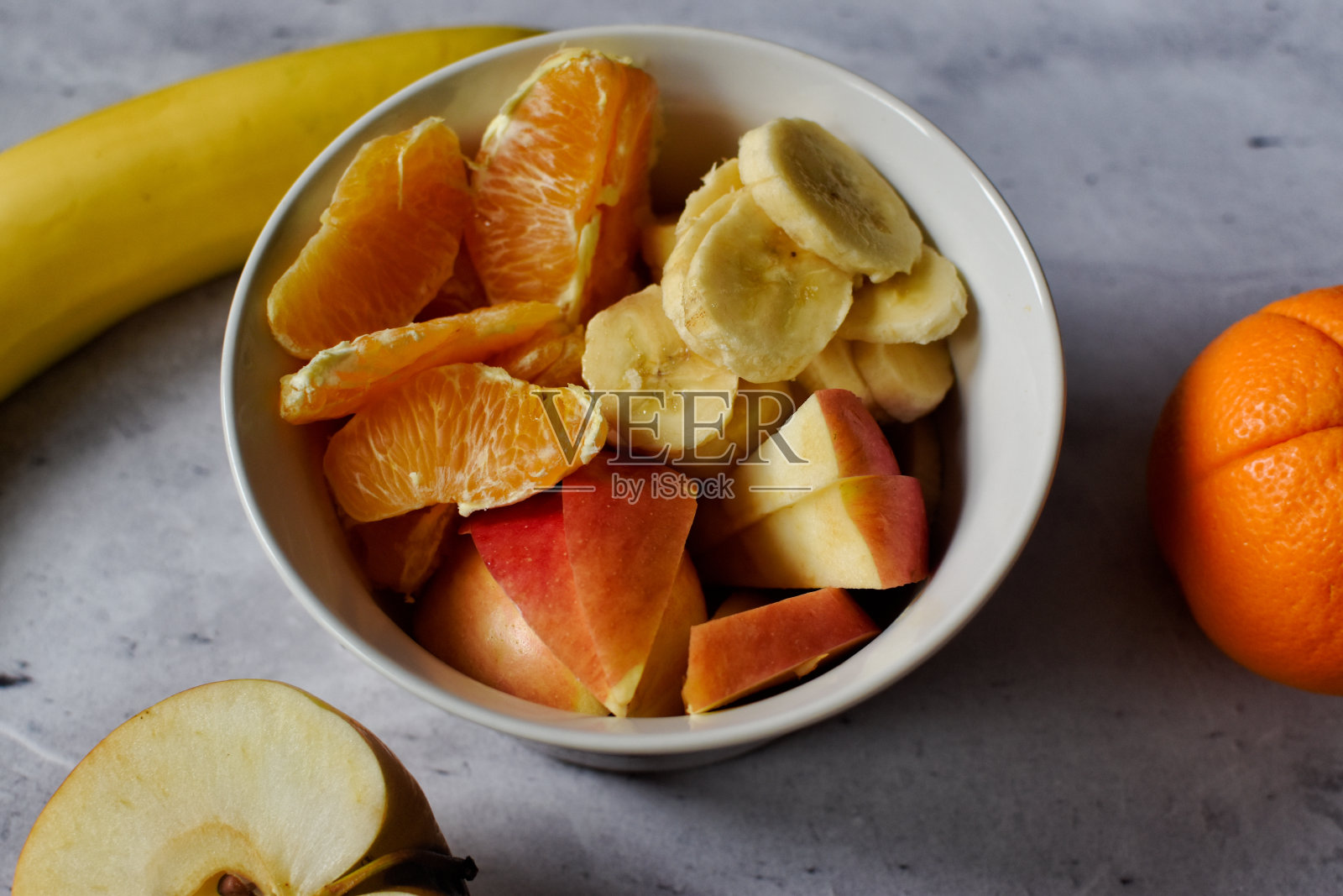 桌上的碗上放着香蕉皮、苹果皮和橘子皮照片摄影图片