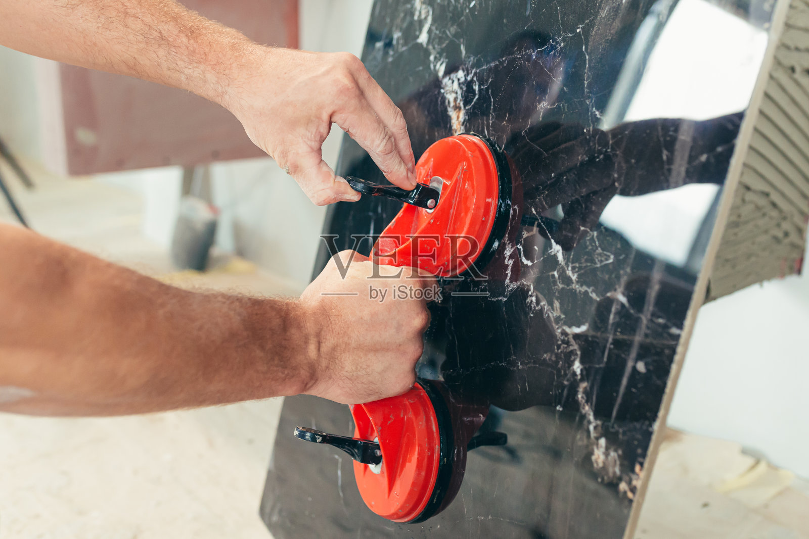 一名男工人在浴室里贴一块大瓷砖照片摄影图片