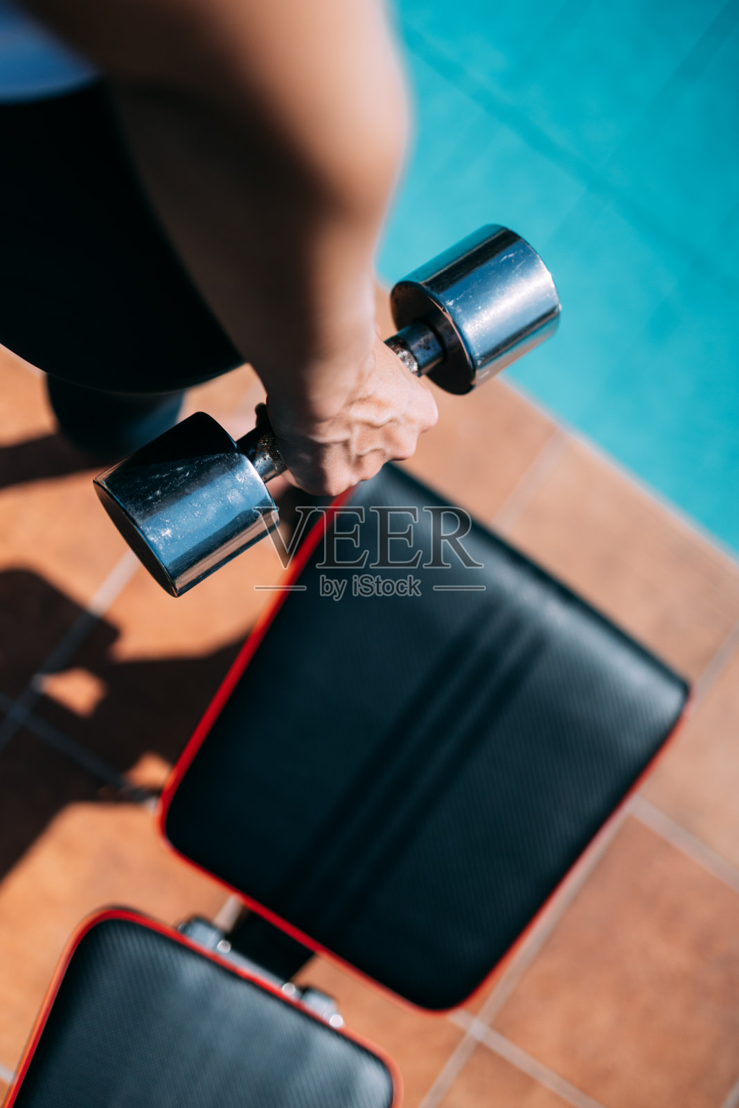 健身女子在泳池边举重，准备做比基尼手术，垂直格式照片摄影图片