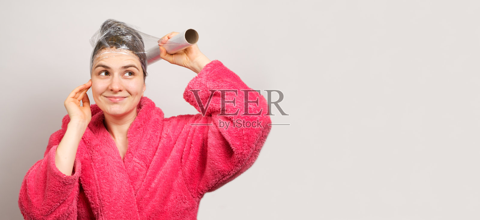 一位美丽的黑发女子用一层透明薄膜、一条围巾和一个发膜包裹她的头，还有一条写有文字的横幅照片摄影图片