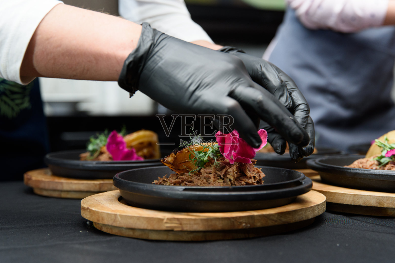 厨师准备了一道美味的瑞士菜，里面有鹿肉、卷心菜、香草和花瓣照片摄影图片