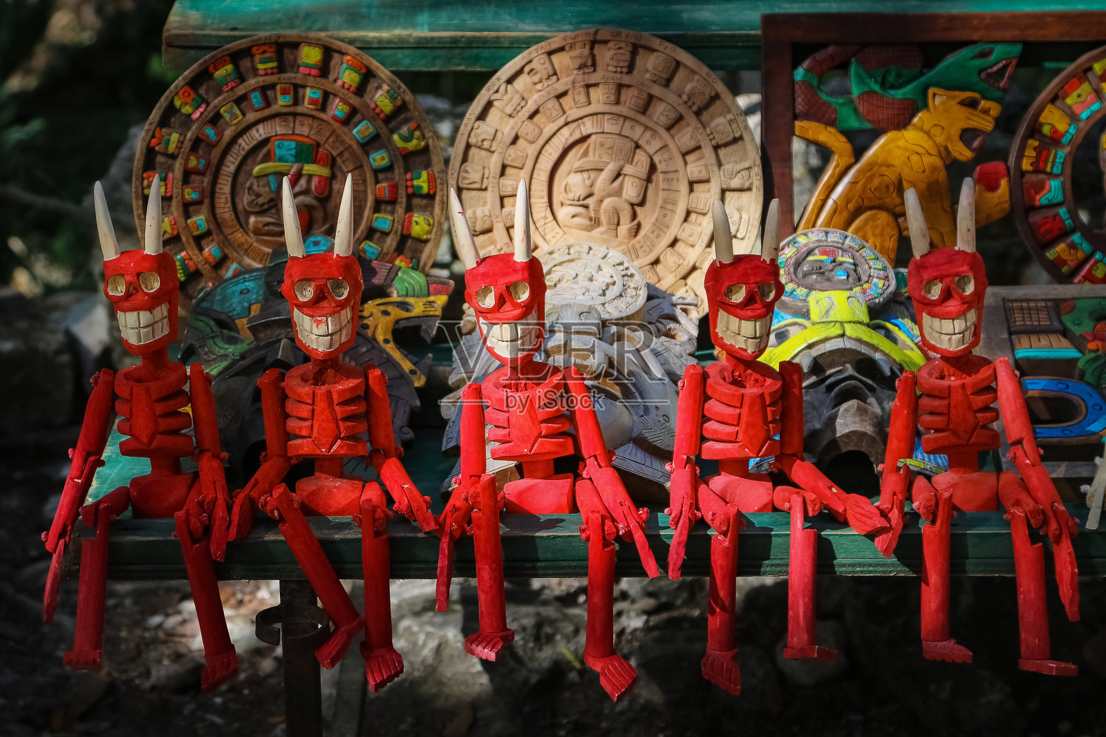 木制的红色骷髅雕像。传统的墨西哥纪念品。照片摄影图片