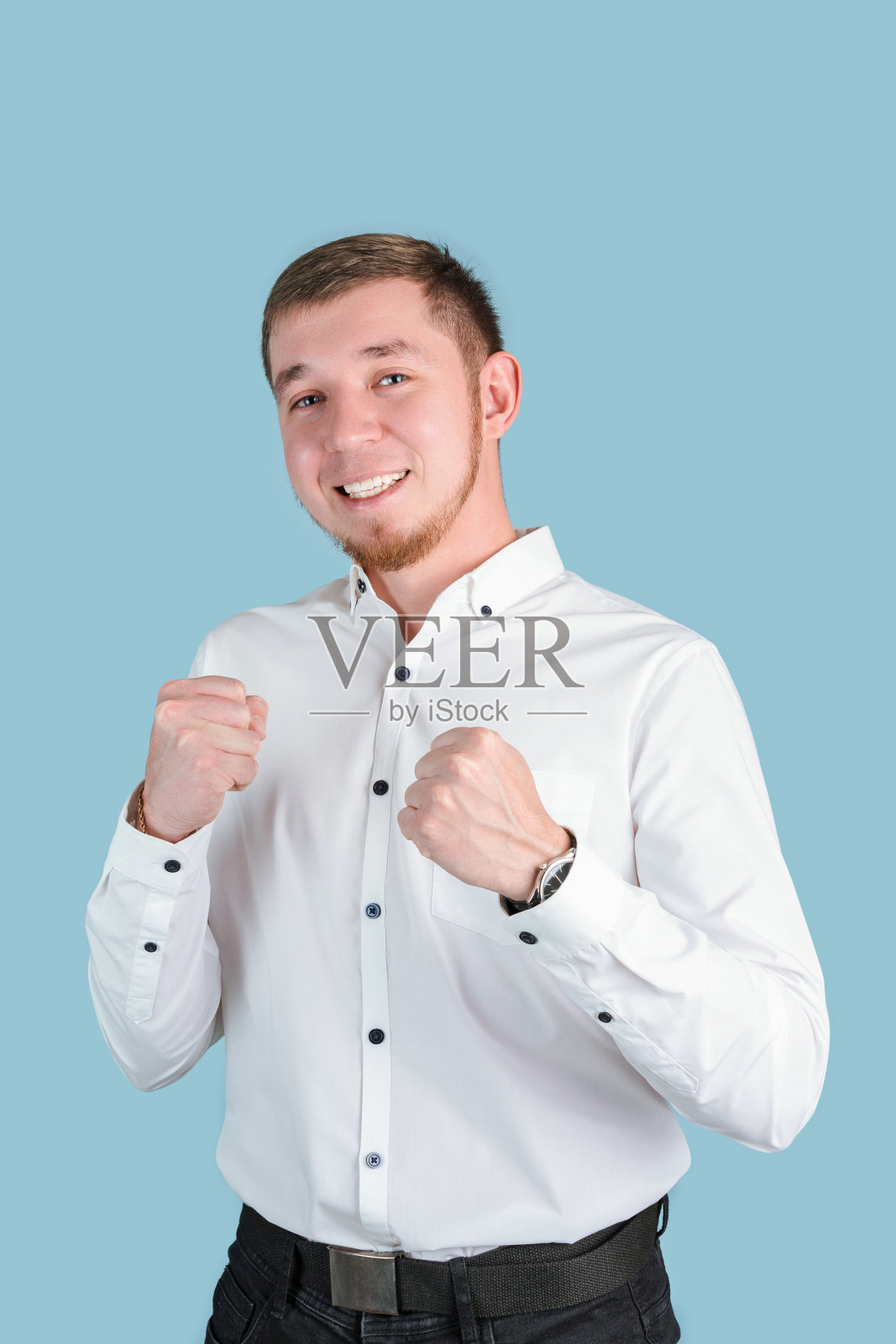 身穿白衬衫的经理双手紧握，站在一张以蓝色为背景的垂直照片上照片摄影图片