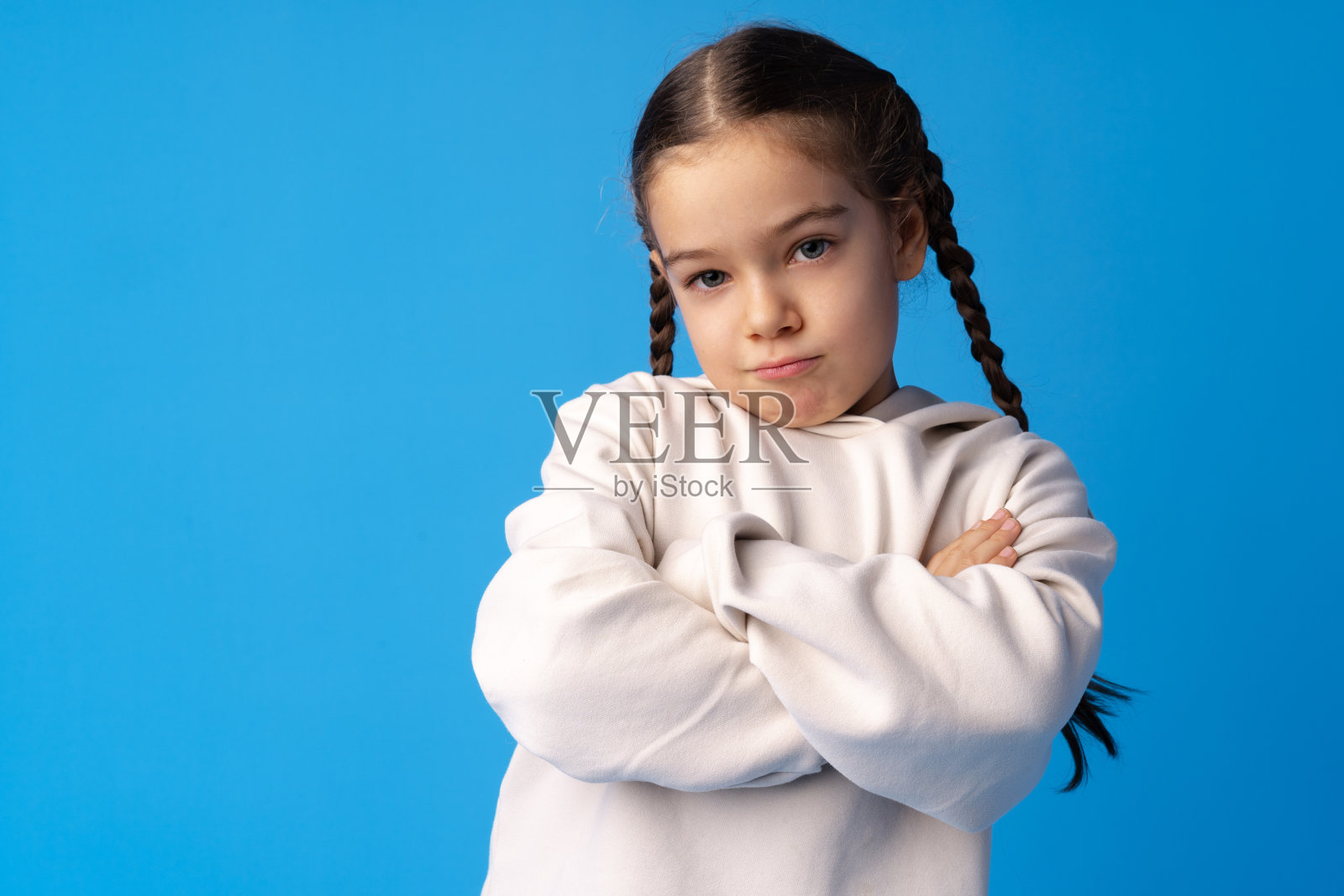 沮丧的小女孩在蓝色背景的肖像照片摄影图片