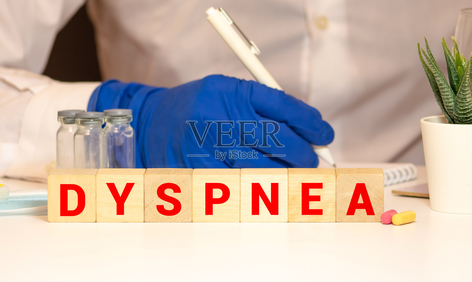 “呼吸困难”这个词是写在听诊器附近的木头方块上，木头做的背景。照片摄影图片