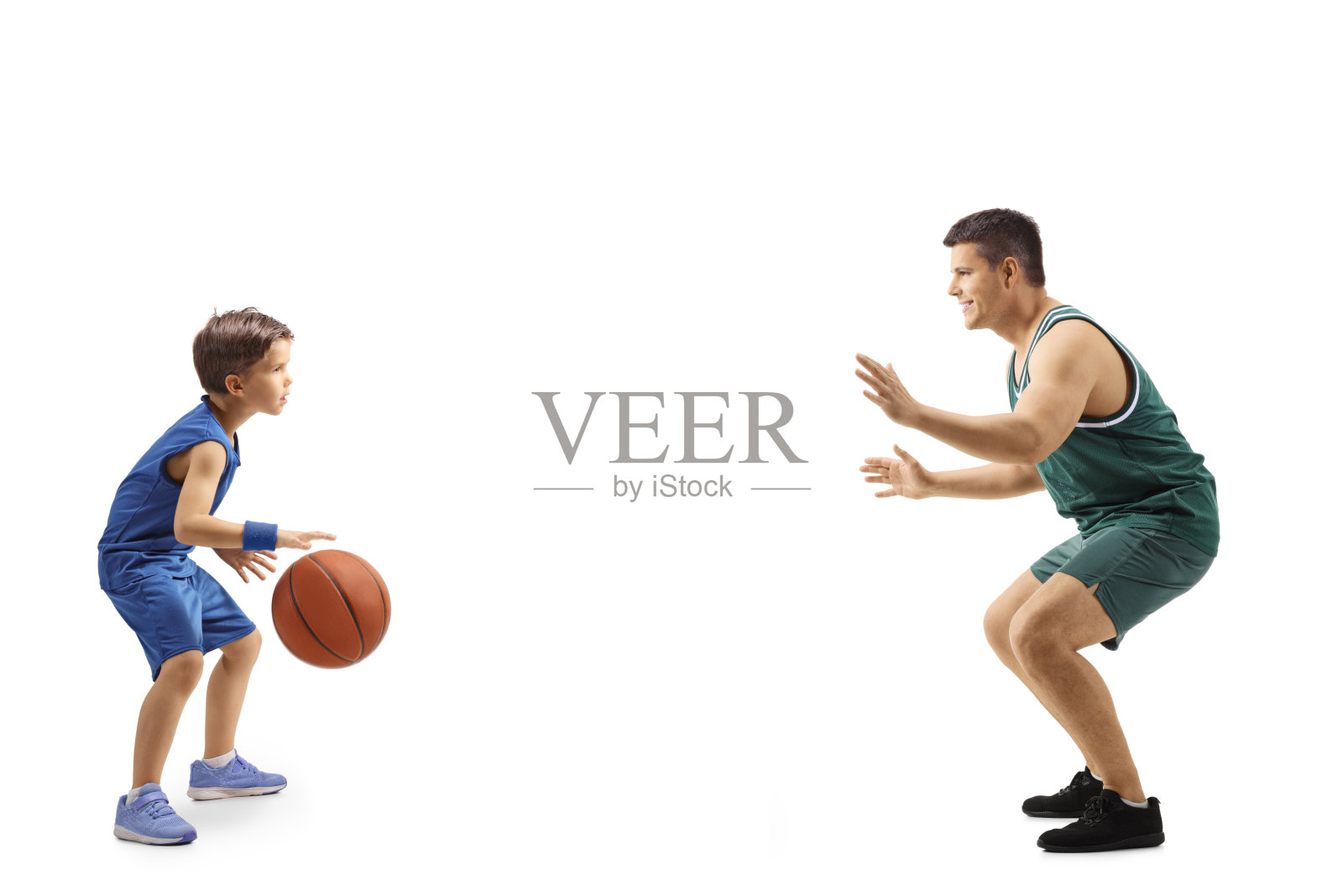 一个男孩和一个成年人打篮球的全长侧面照片照片摄影图片