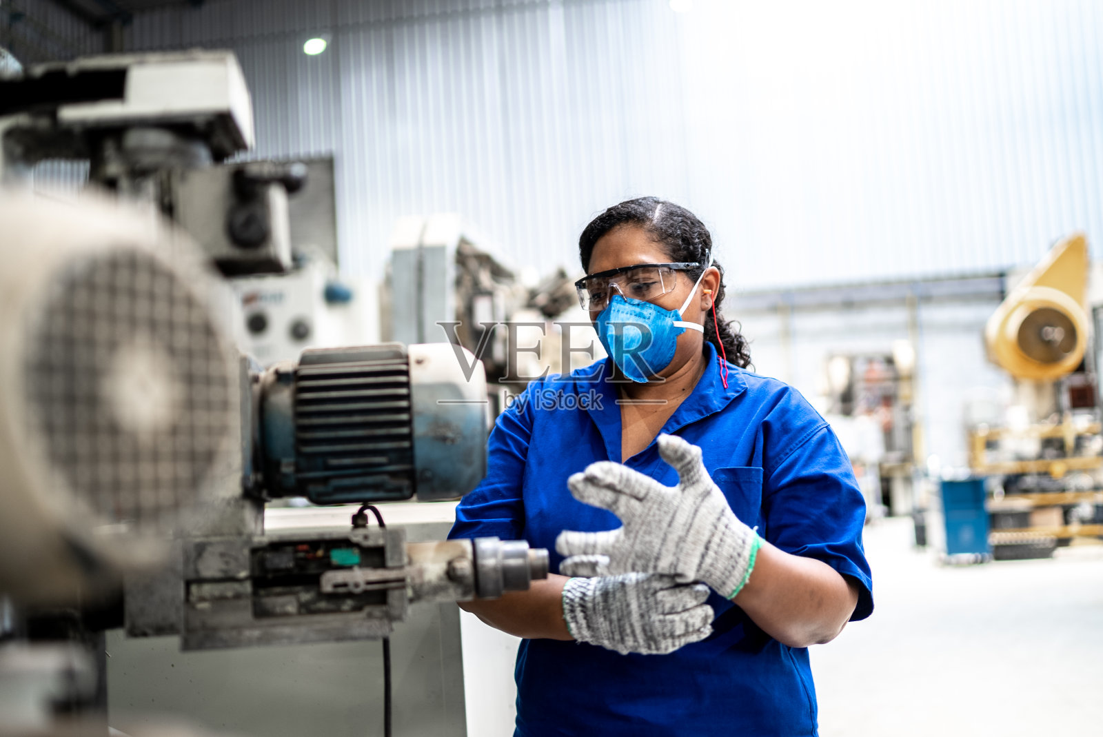 在工厂/工业中工作的中年妇女——戴着口罩照片摄影图片