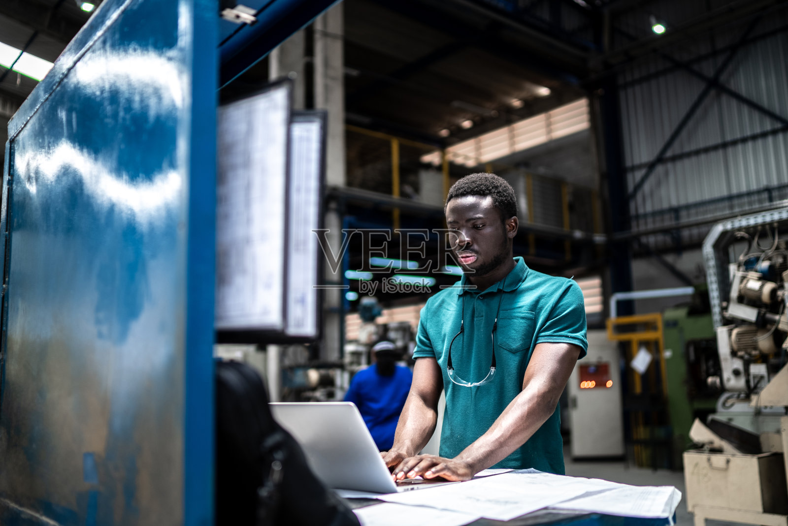 在工厂/工业中使用笔记本电脑的年轻人照片摄影图片