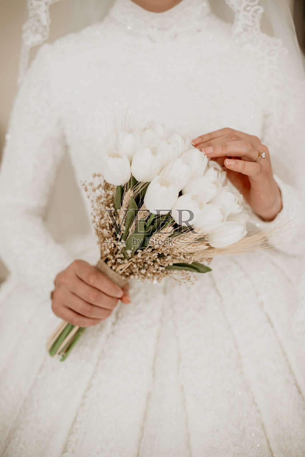 新娘手中的新娘花，集中在一只手上和郁金香照片摄影图片