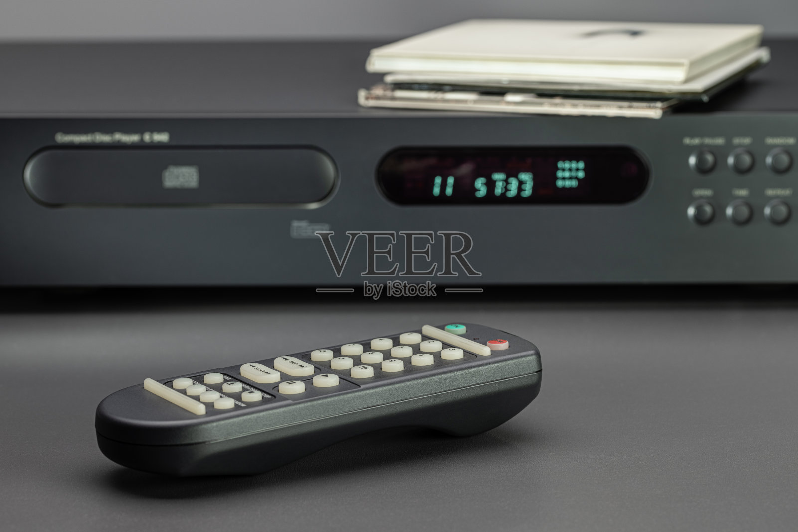 CD播放机和声音控制面板，特写。光盘装在信封里，放在播放器的封面上。照片摄影图片