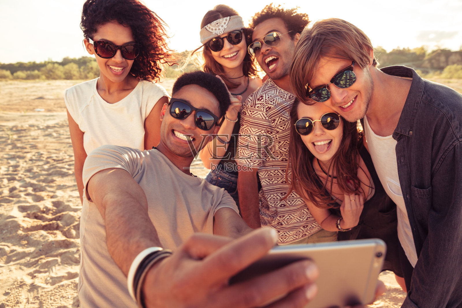 兴奋的年轻朋友们在海滩上自拍照片摄影图片