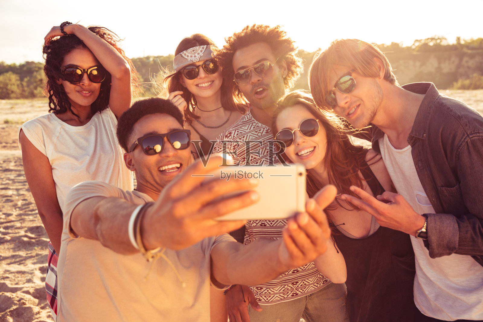 兴奋的年轻朋友们在海滩上自拍照片摄影图片