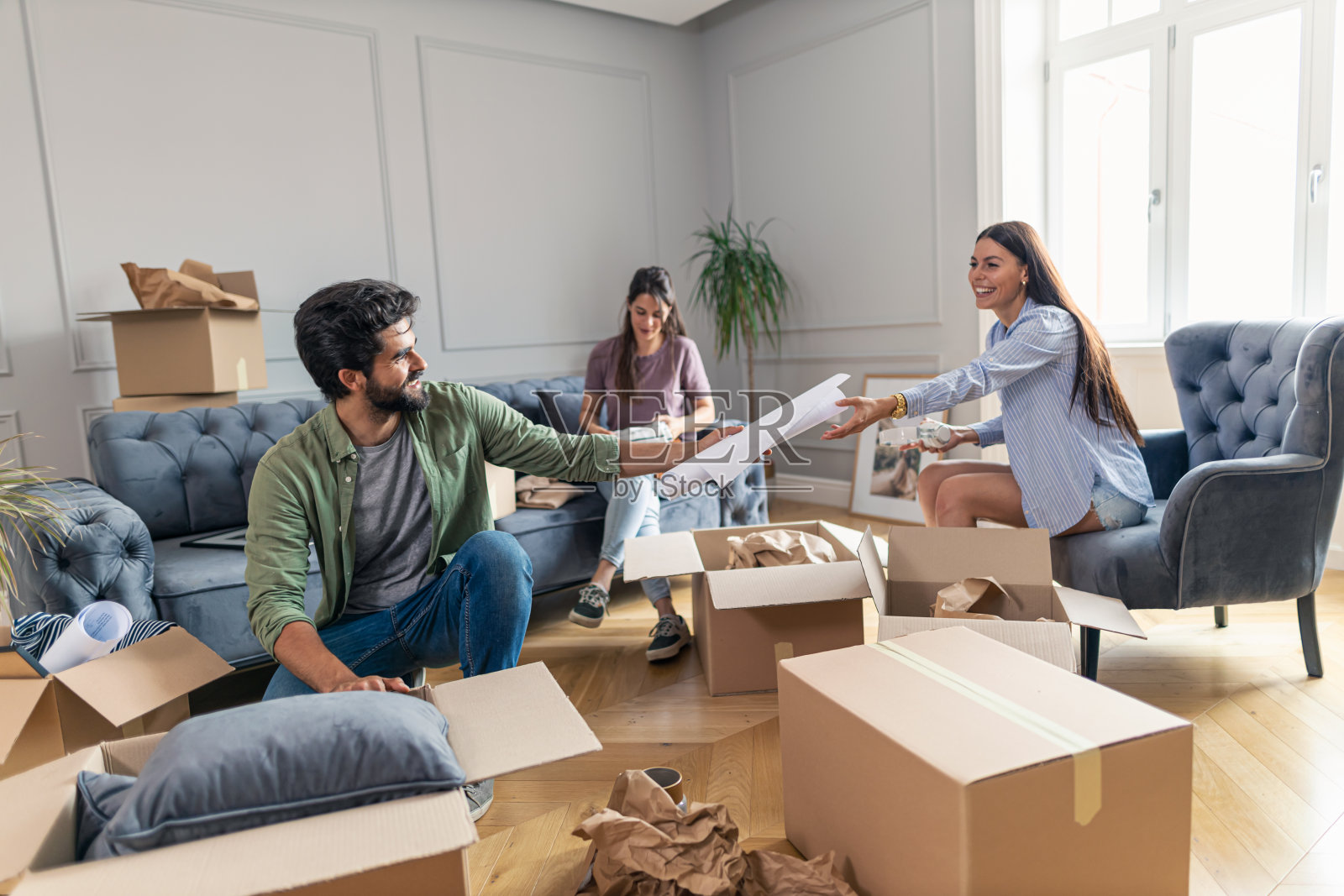 一个人把设计图给他的朋友看，这样他们就可以想出如何装饰他们的新公寓的主意。照片摄影图片