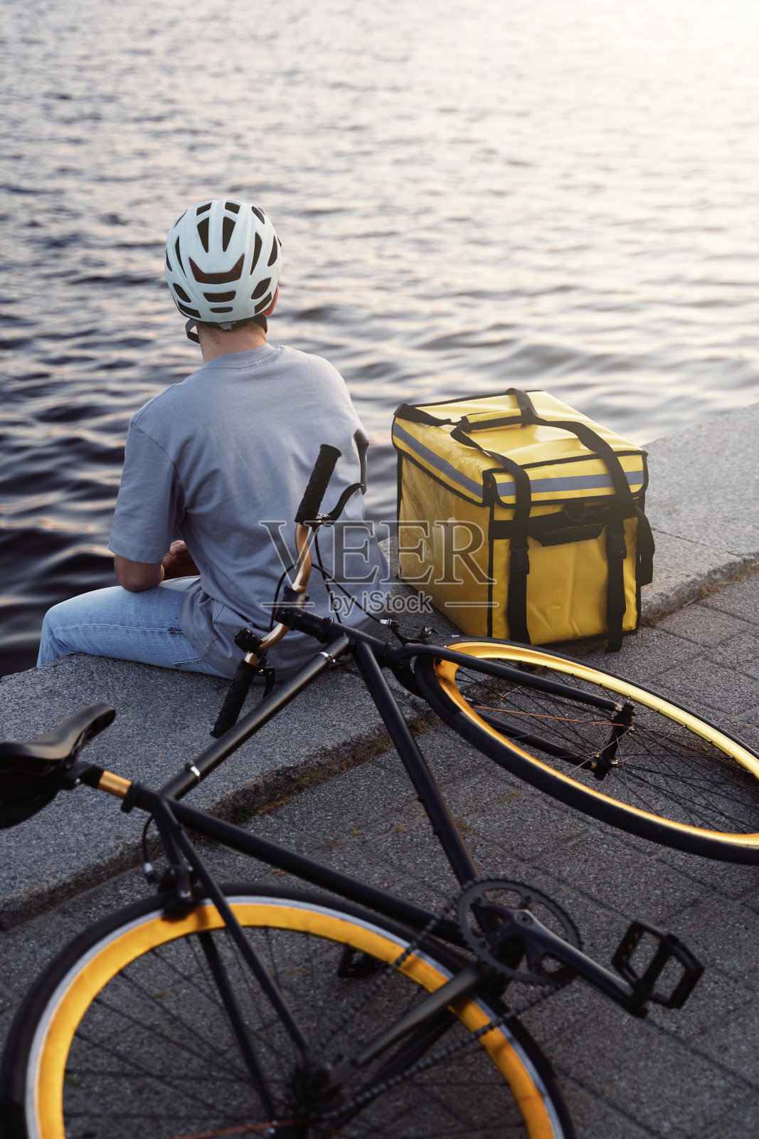 快递快递坐在码头看河。照片摄影图片