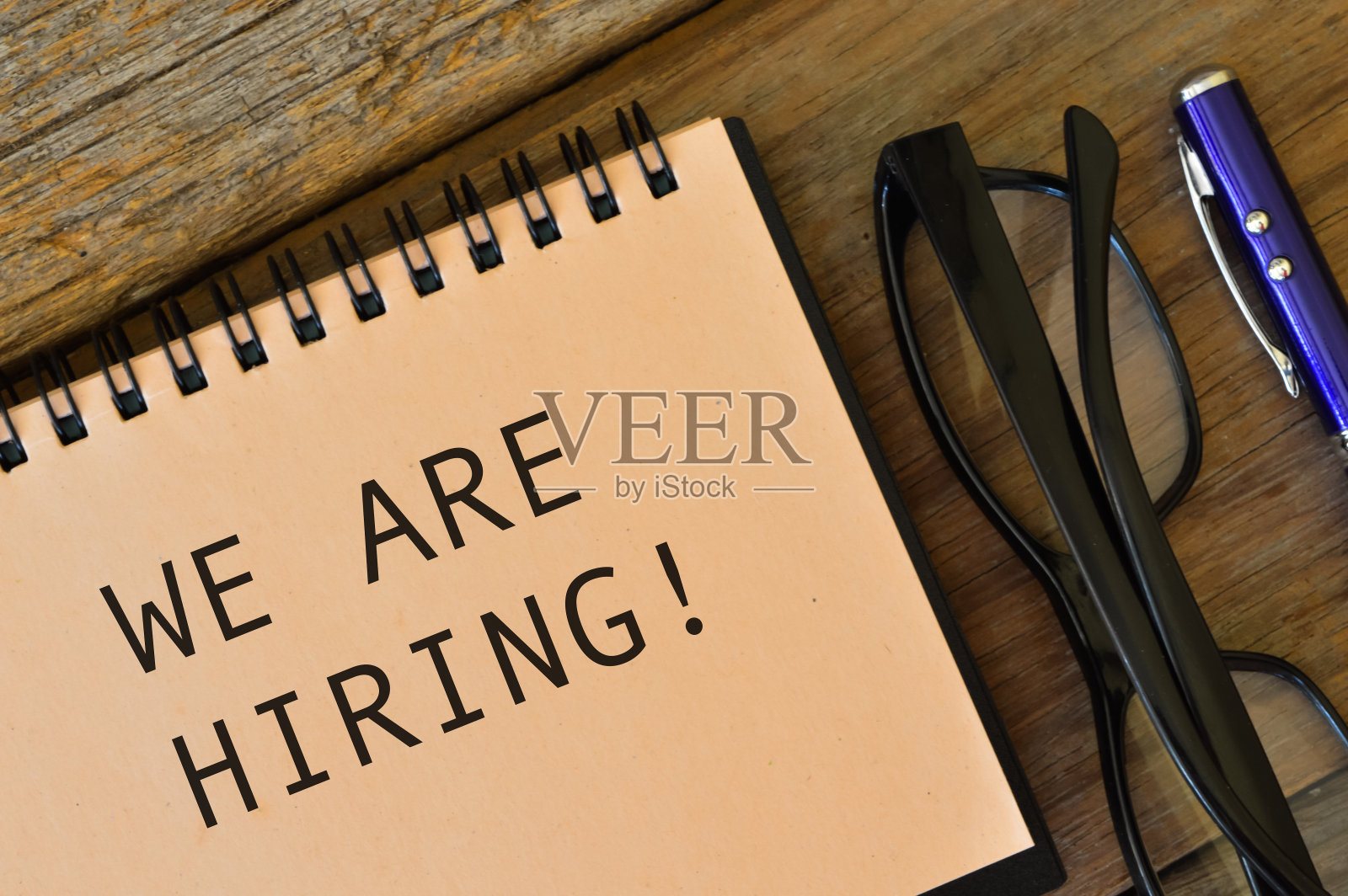 眼镜和笔记本上写着“我们正在招聘!”照片摄影图片