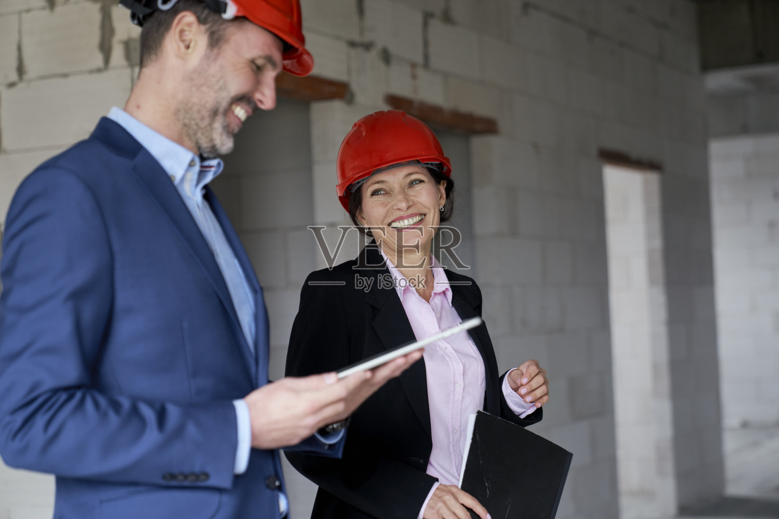 女性白人工程师和女商人持文件，而站在工地上照片摄影图片