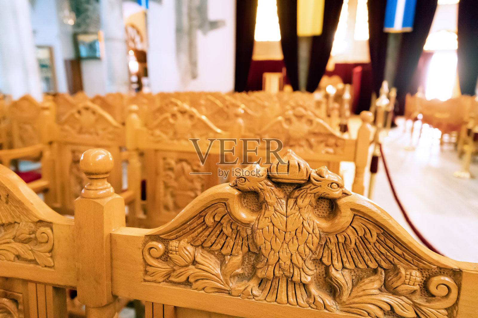 在雄伟的圣迪米特里奥教堂内部的木凳上雕刻着双头鹰。朝拜观念照片摄影图片