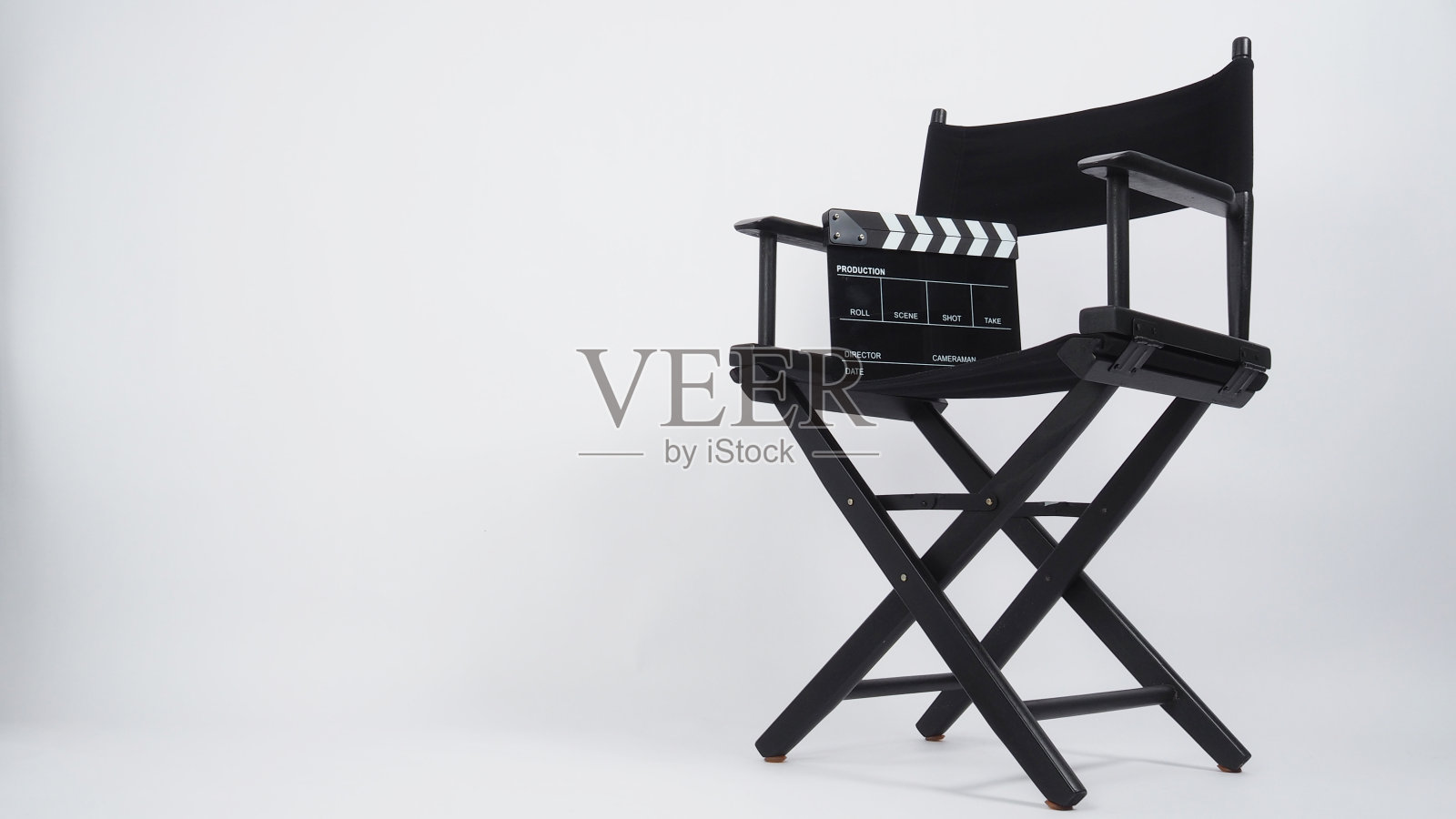 黑色拍板或电影板与导演椅，用于视频制作或电影和电影行业。背景是白色的。照片摄影图片