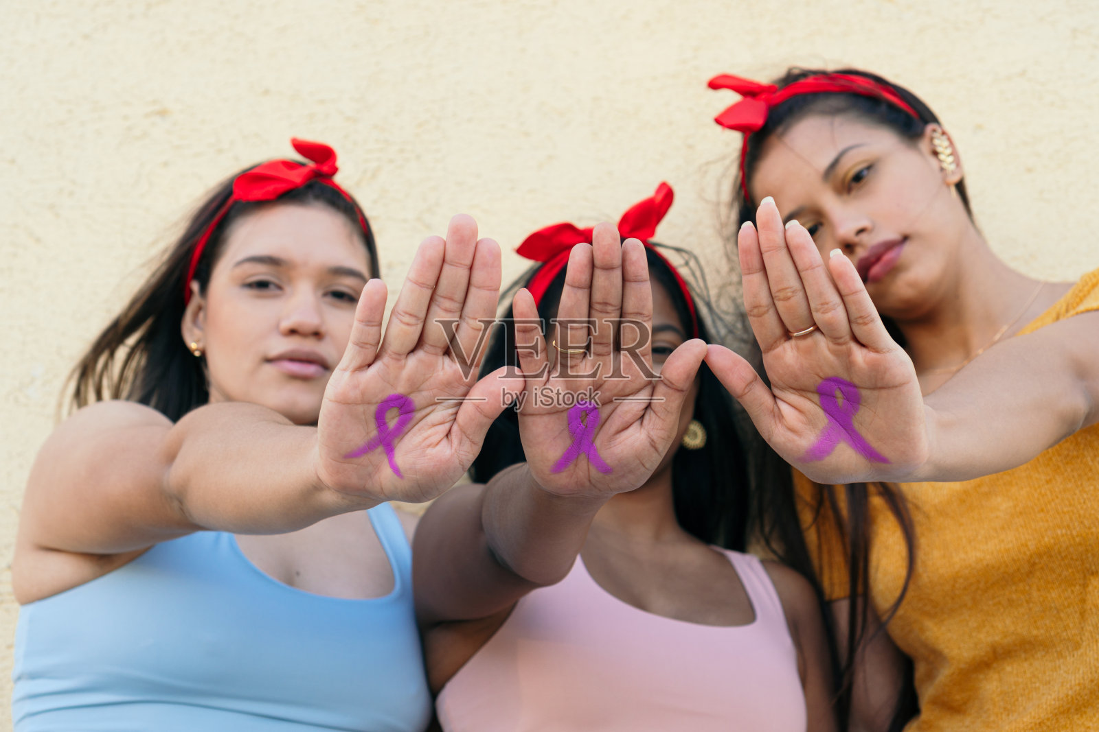 三位乳腺癌象征的女性在手上作画照片摄影图片