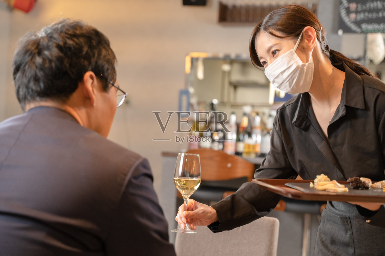 女职员和男顾客都戴着口罩提供预防传染病的餐食照片摄影图片