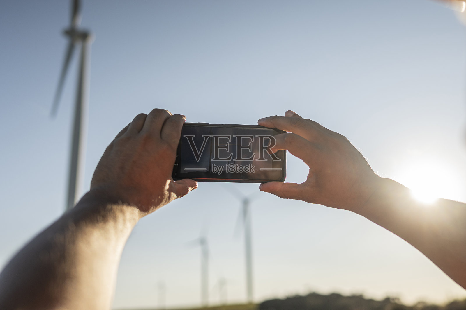 电气工程师/技术员用手机拍摄风电场照片摄影图片