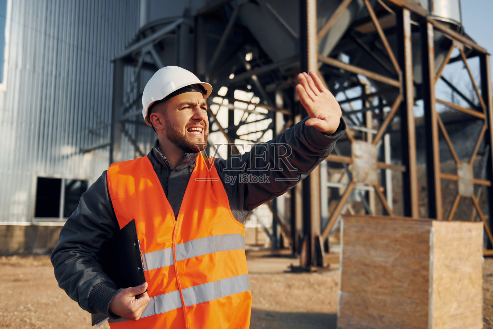 显示停止动作。穿制服的建筑工人在工厂附近的户外活动照片摄影图片