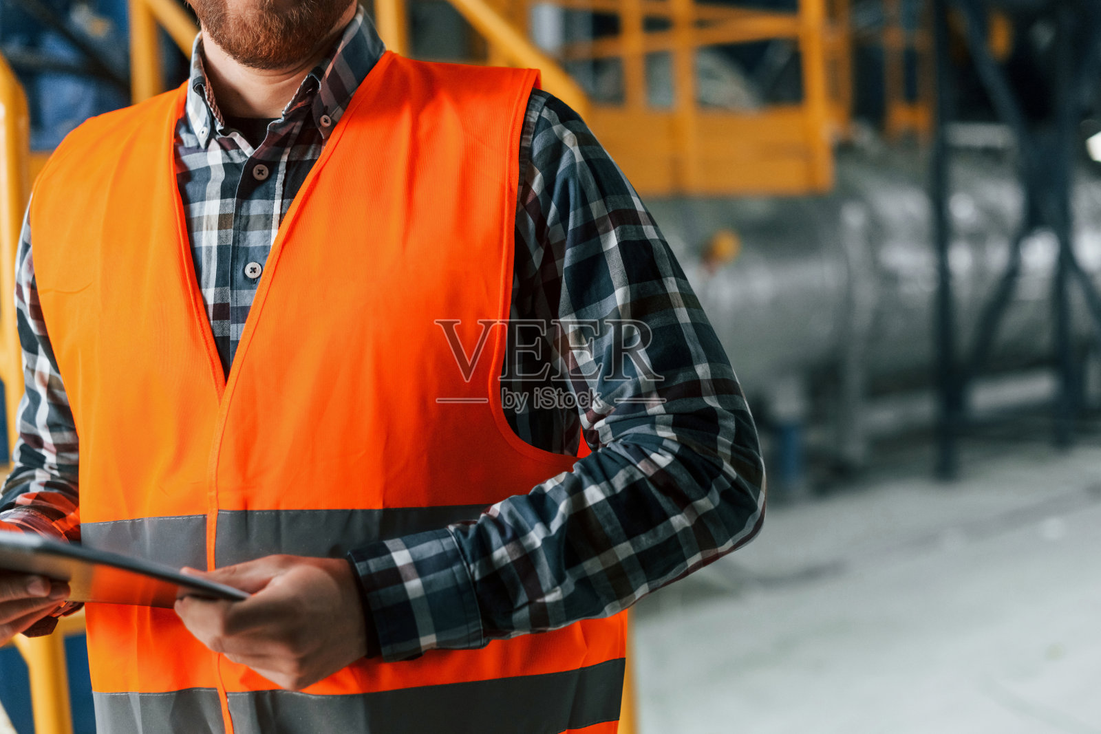 关闭视图。穿制服的建筑工人在工厂里照片摄影图片