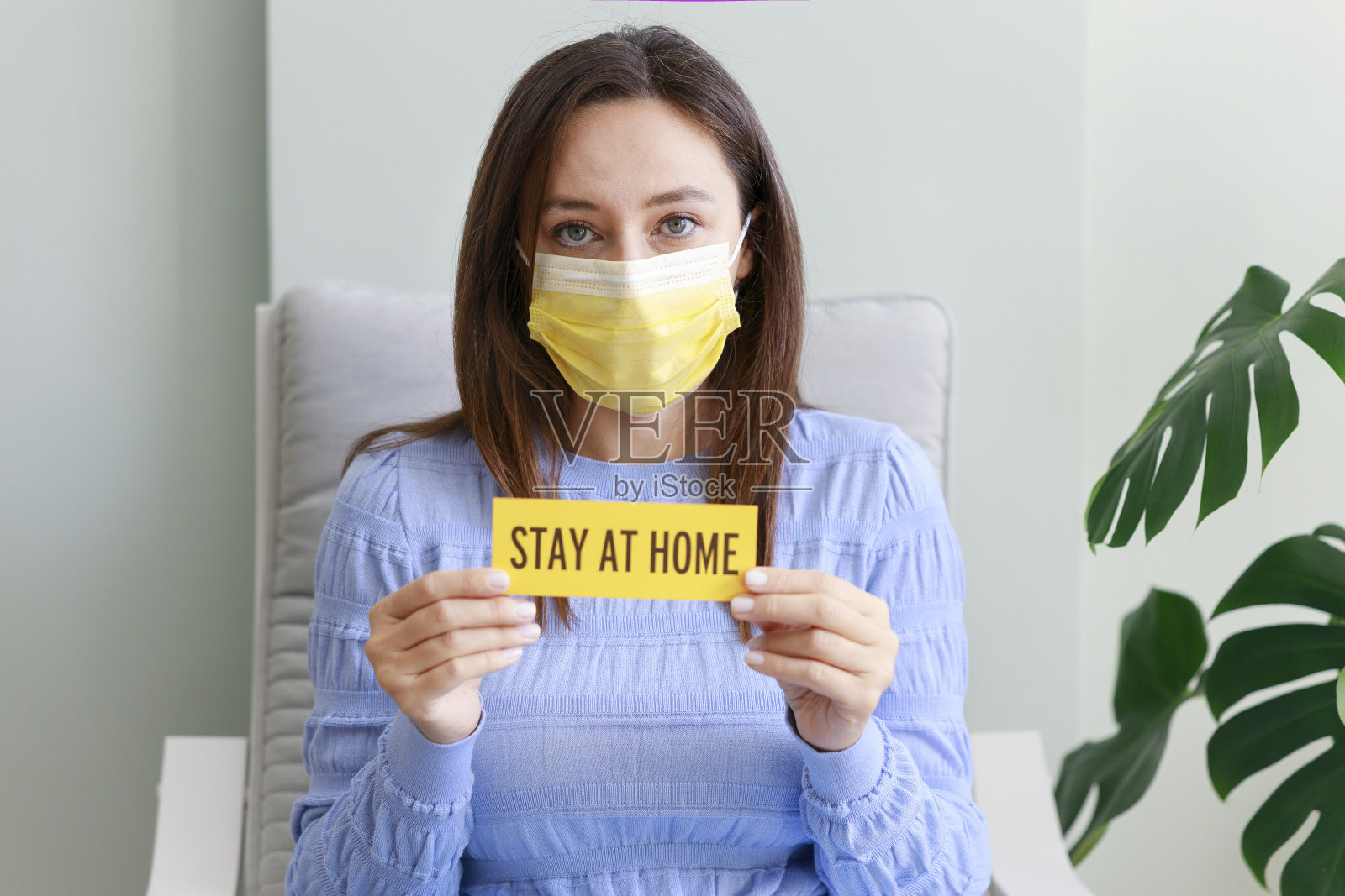 一名年轻女子展示了这封信，她呆在家里，写在一张纸上照片摄影图片