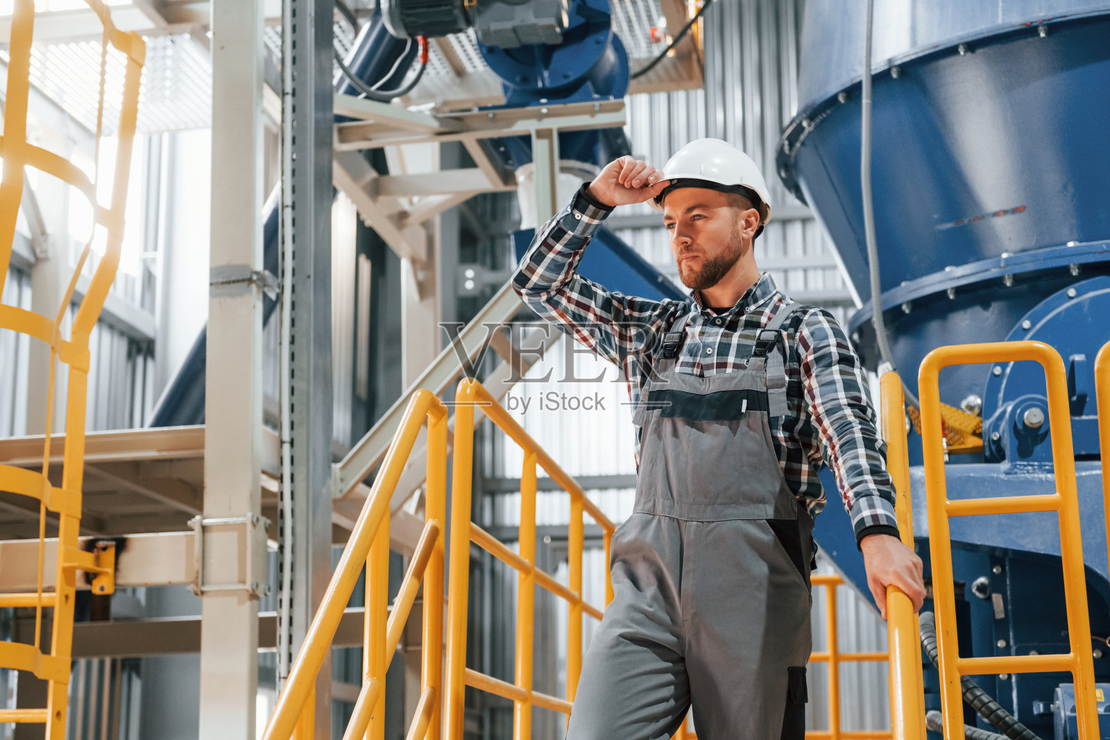 工程师是在室内。穿制服的建筑工人在工厂里照片摄影图片