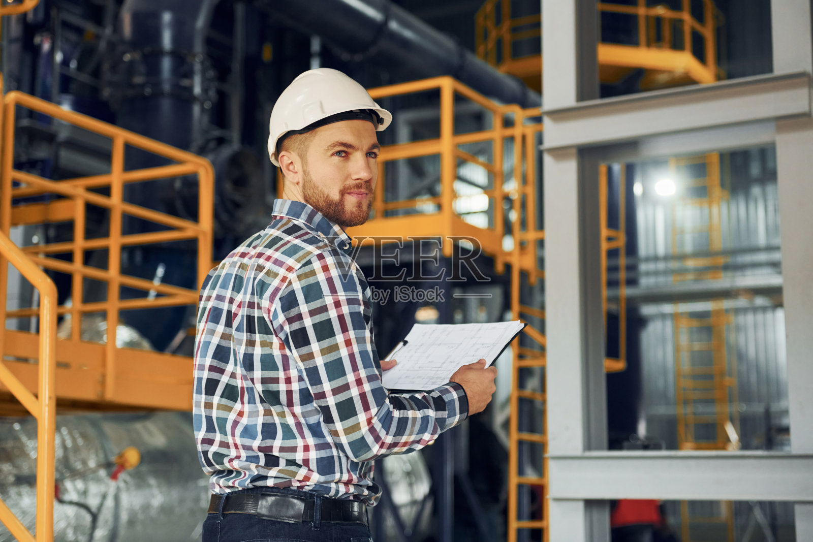 工程师是在室内。穿制服的建筑工人在工厂里照片摄影图片